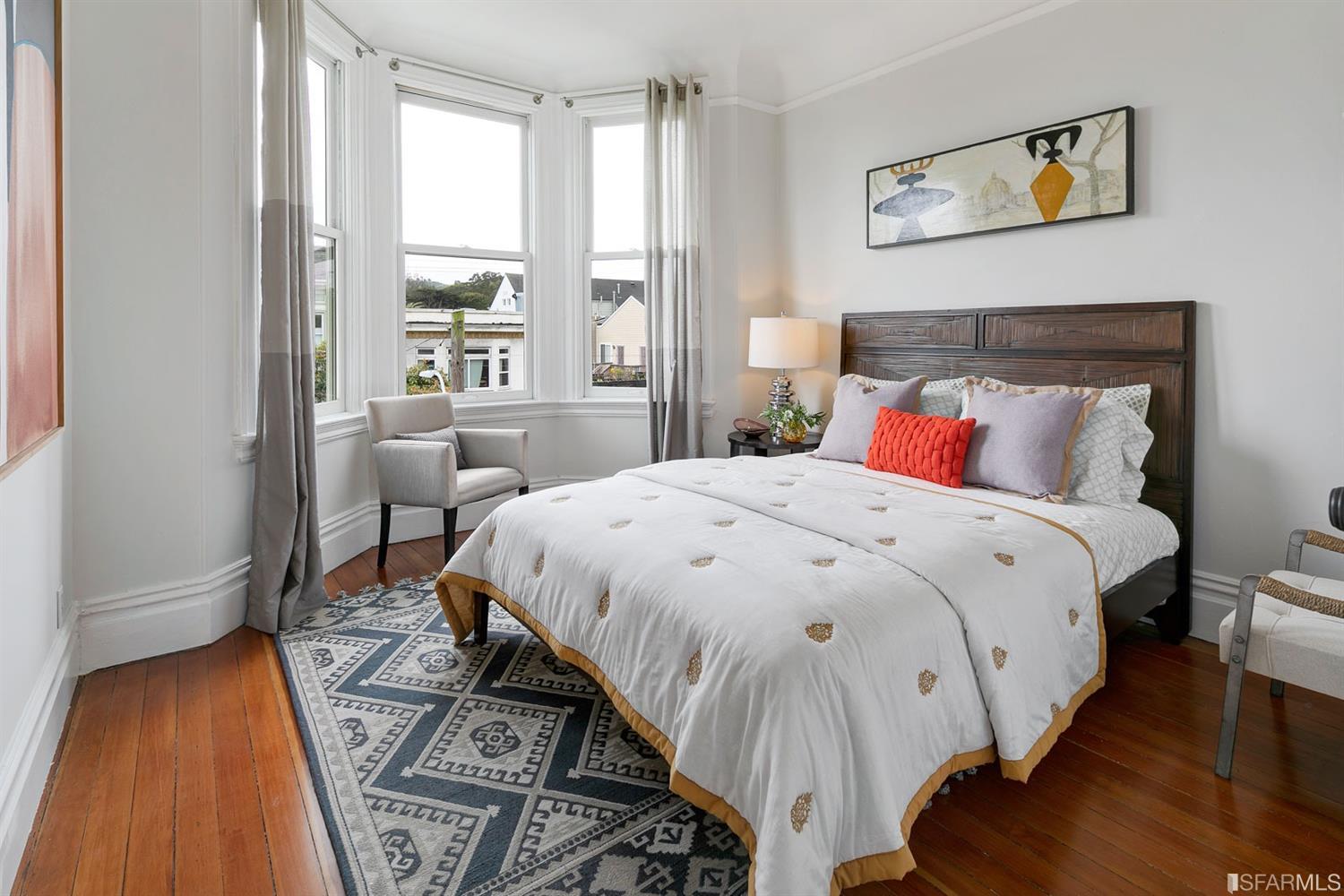 View of a third bedroom with bay windows and wood floors