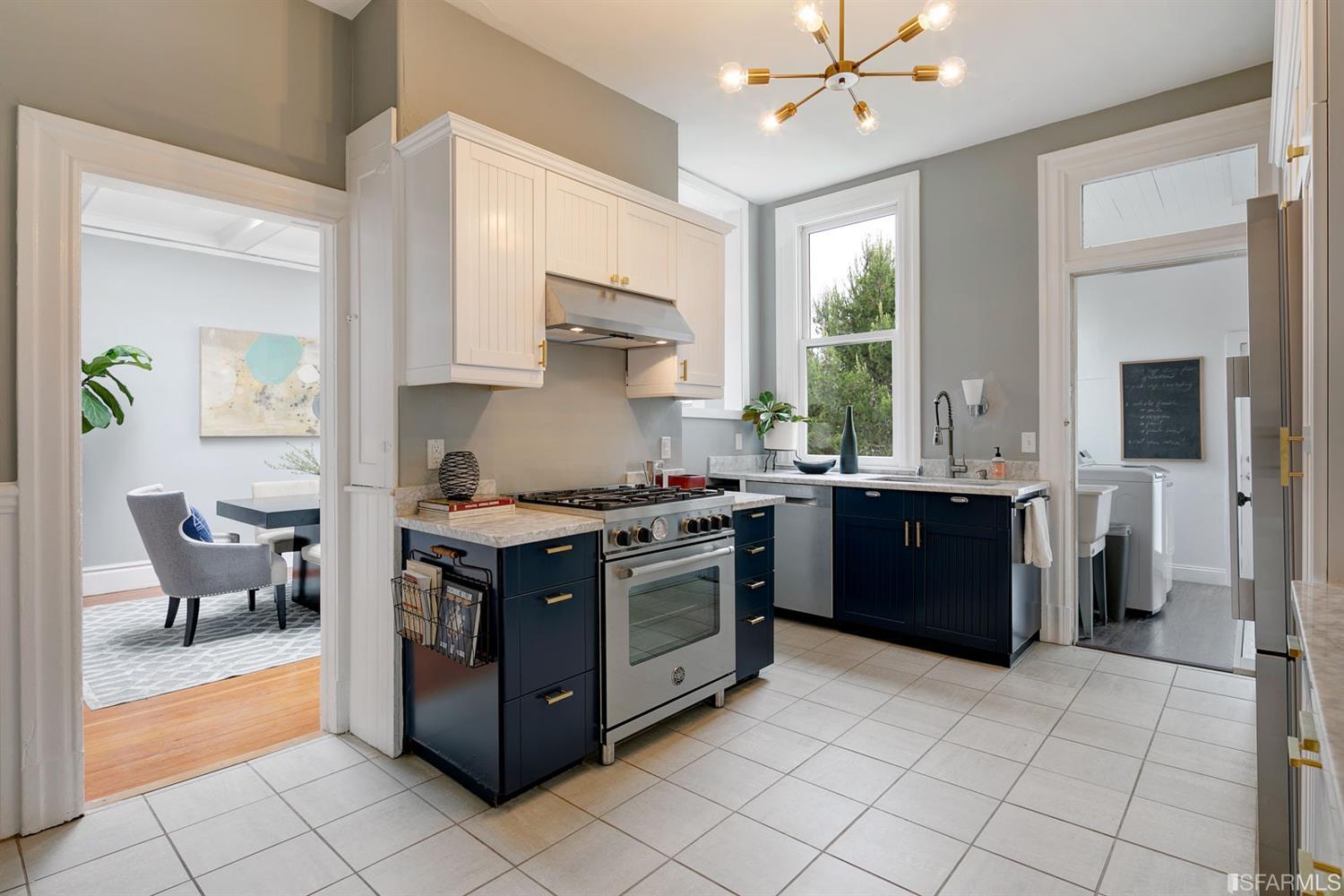 View of the kitchen, showing a stainless stove and window above the sink