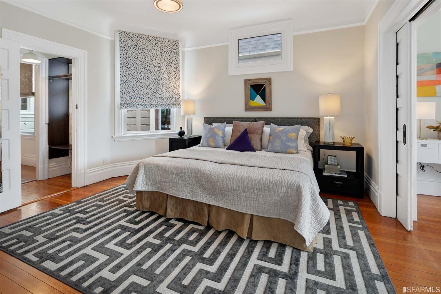 View of a bedroom with wood floors and a window