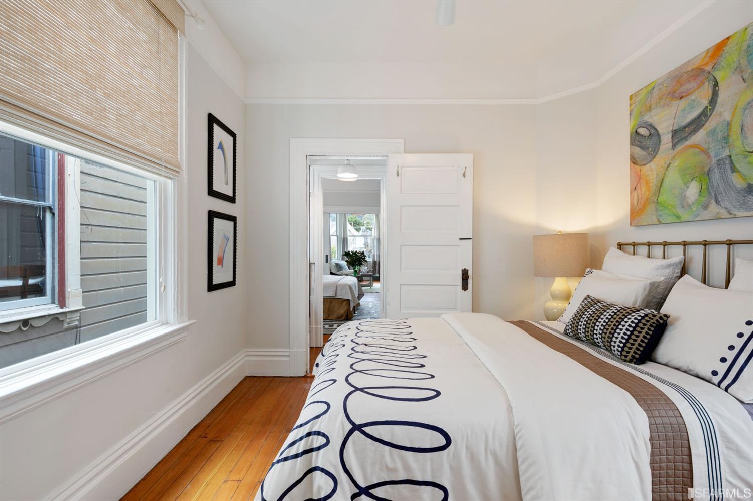 View of another bedroom with wood floors and crown moulding