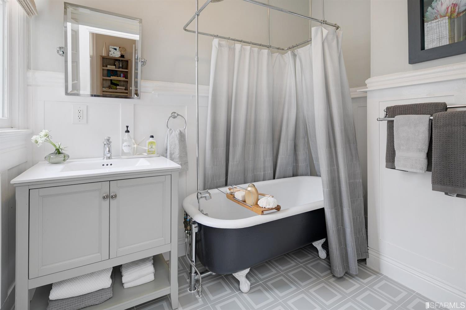Bathroom with free-standing bath tub and white wainscoting