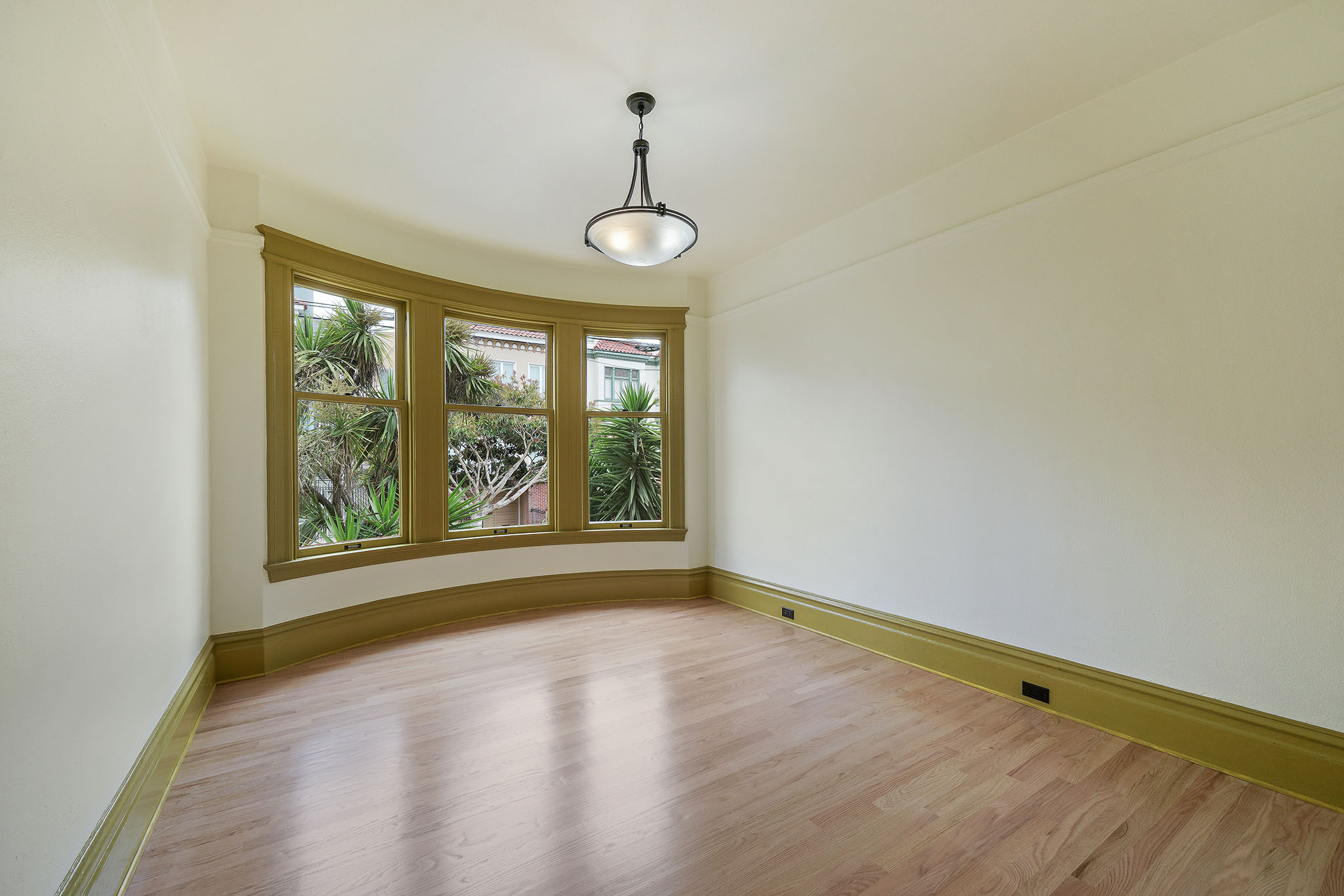 View of an unfurnished room, featuring wood floors and large windows