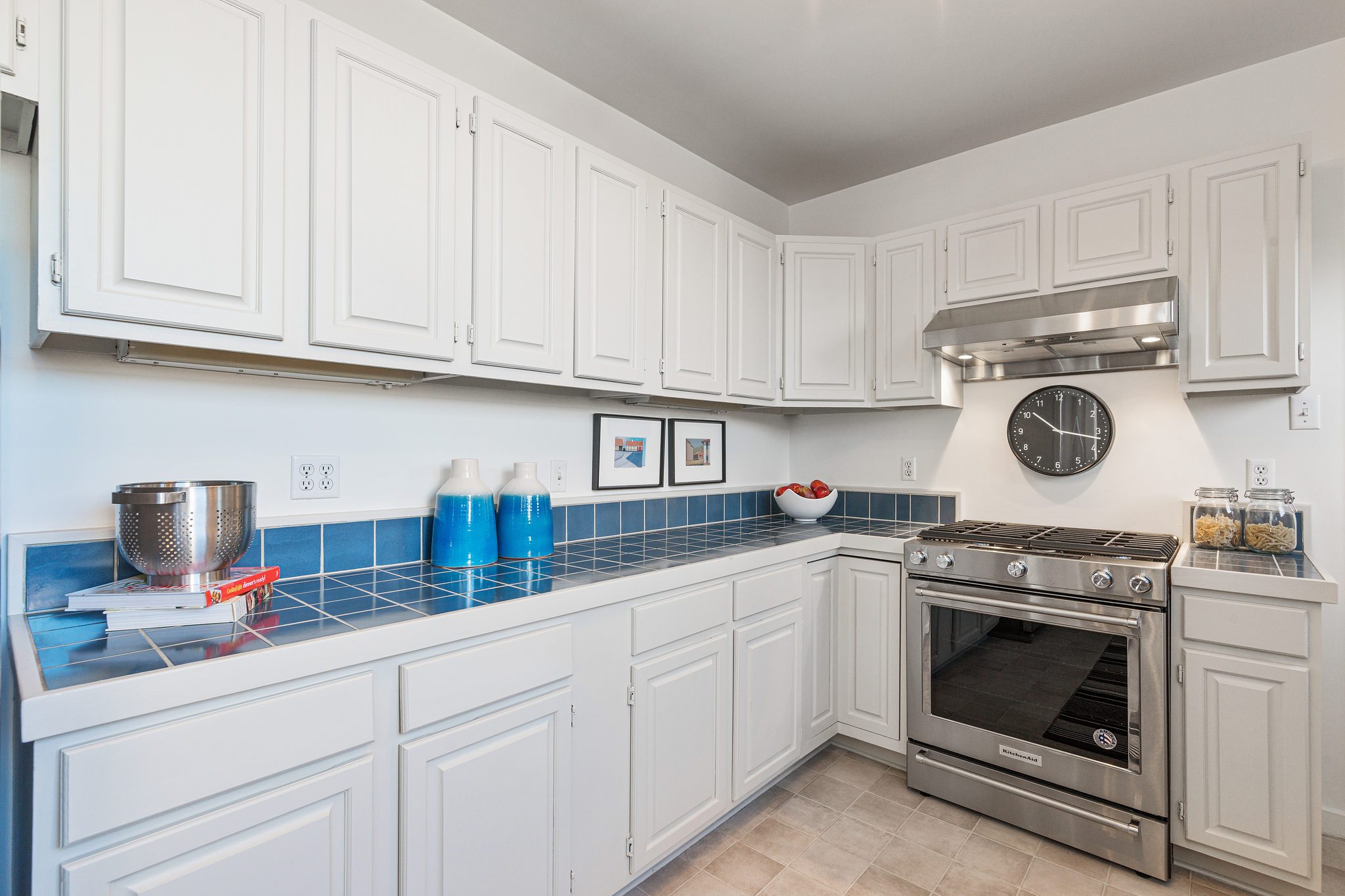 View of the kitchen, showing the primary cooking area and blue tile counter-tops