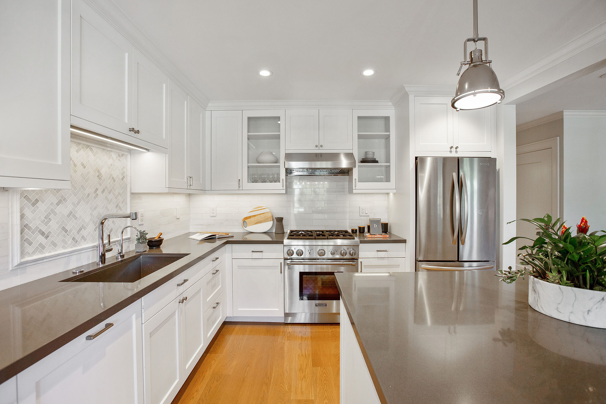 Upper cabinets on both sides of stove hood have see through glass doors.  All other cabinet doors are white wood.