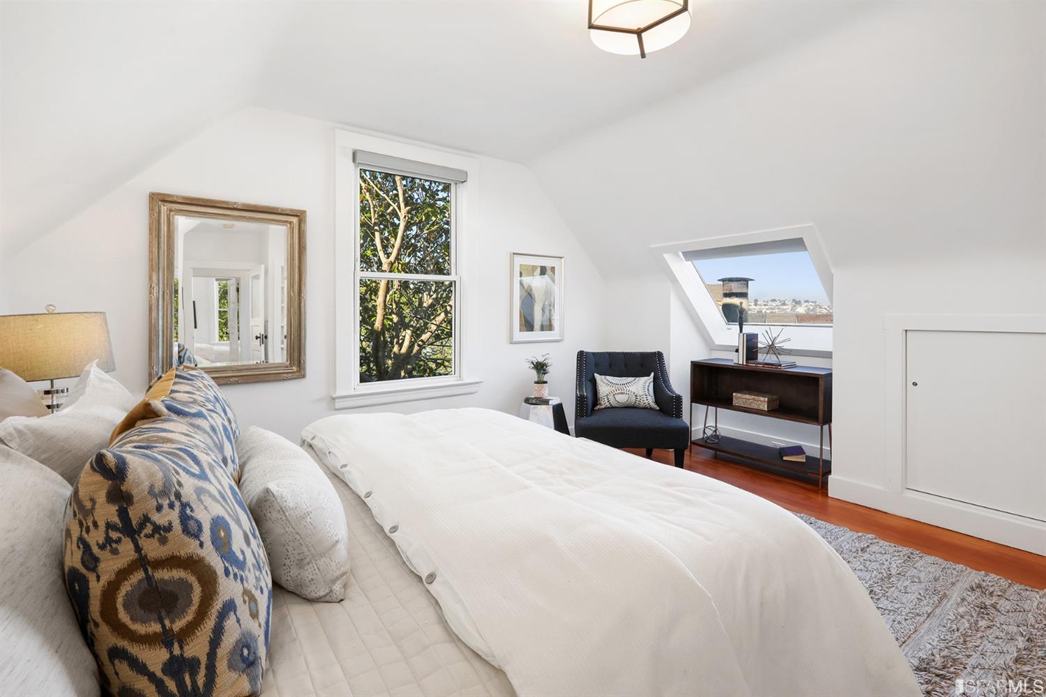 View of a bedroom with a skylight and sloped ceilings