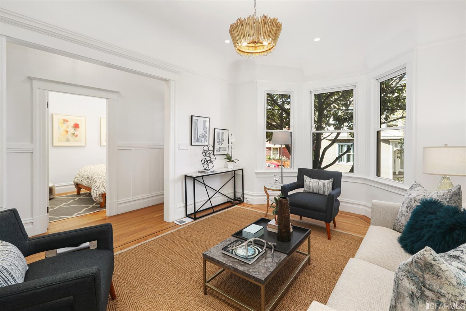 View of the living room with wood floors and a bay window