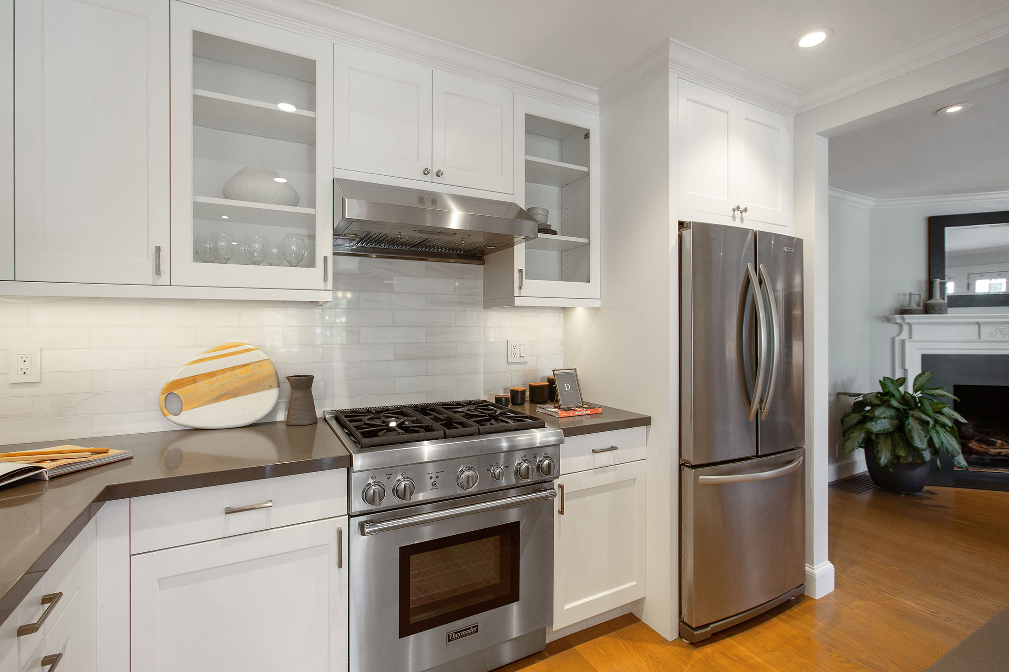 There is a stainless steel gas 4 burner stove with large stainless fridge to the right.