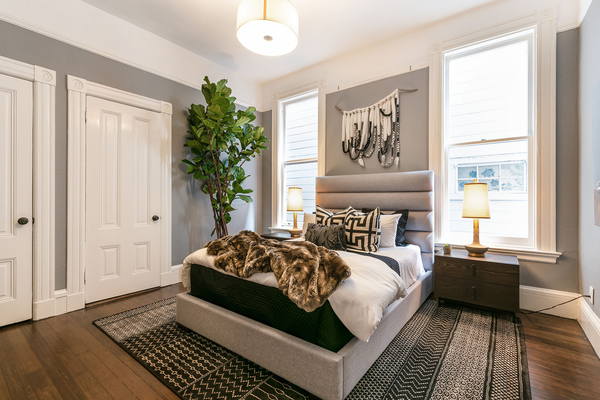 21 Primary bedroom with two large windows and wood floors