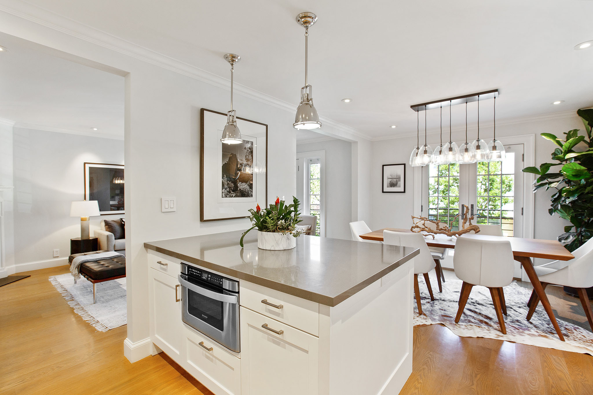 Photo looking over kitchen island with dining space to the right and main entry to the left.