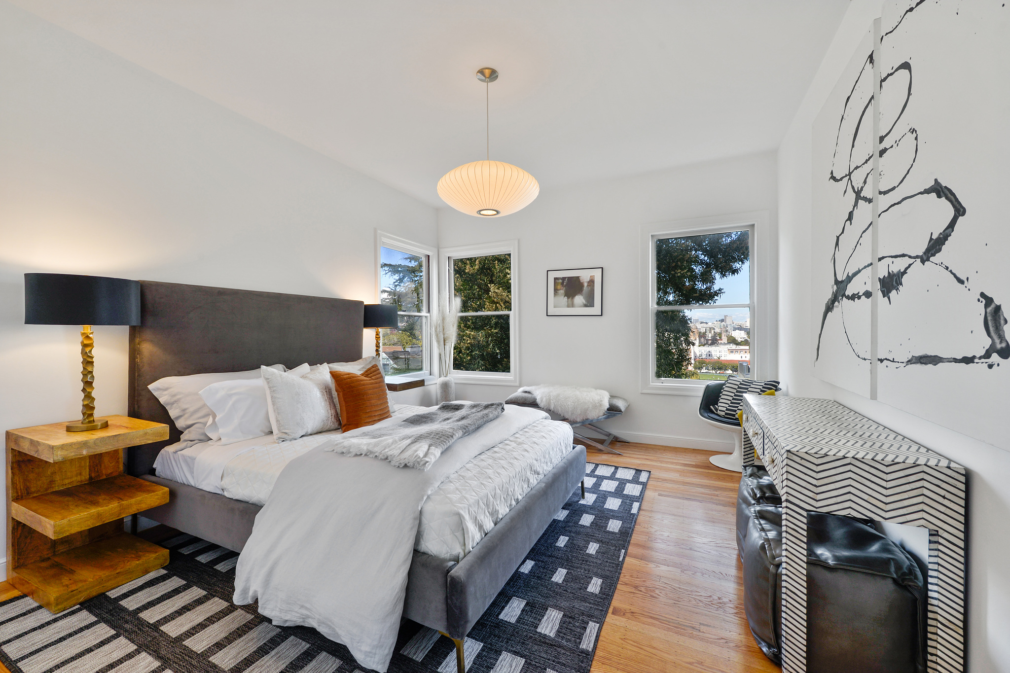 Large bedroom with three windows and wood floors