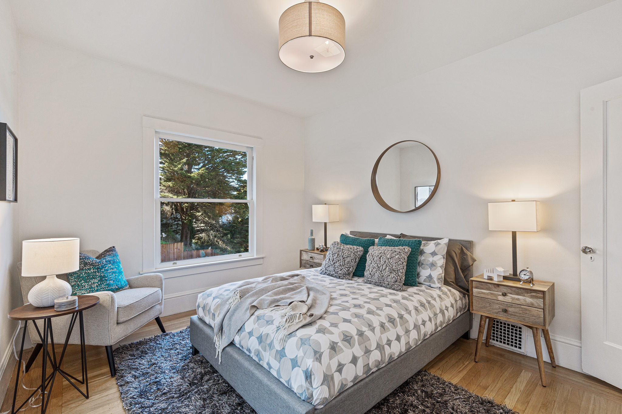 View of a bedroom with a large window and wood floor