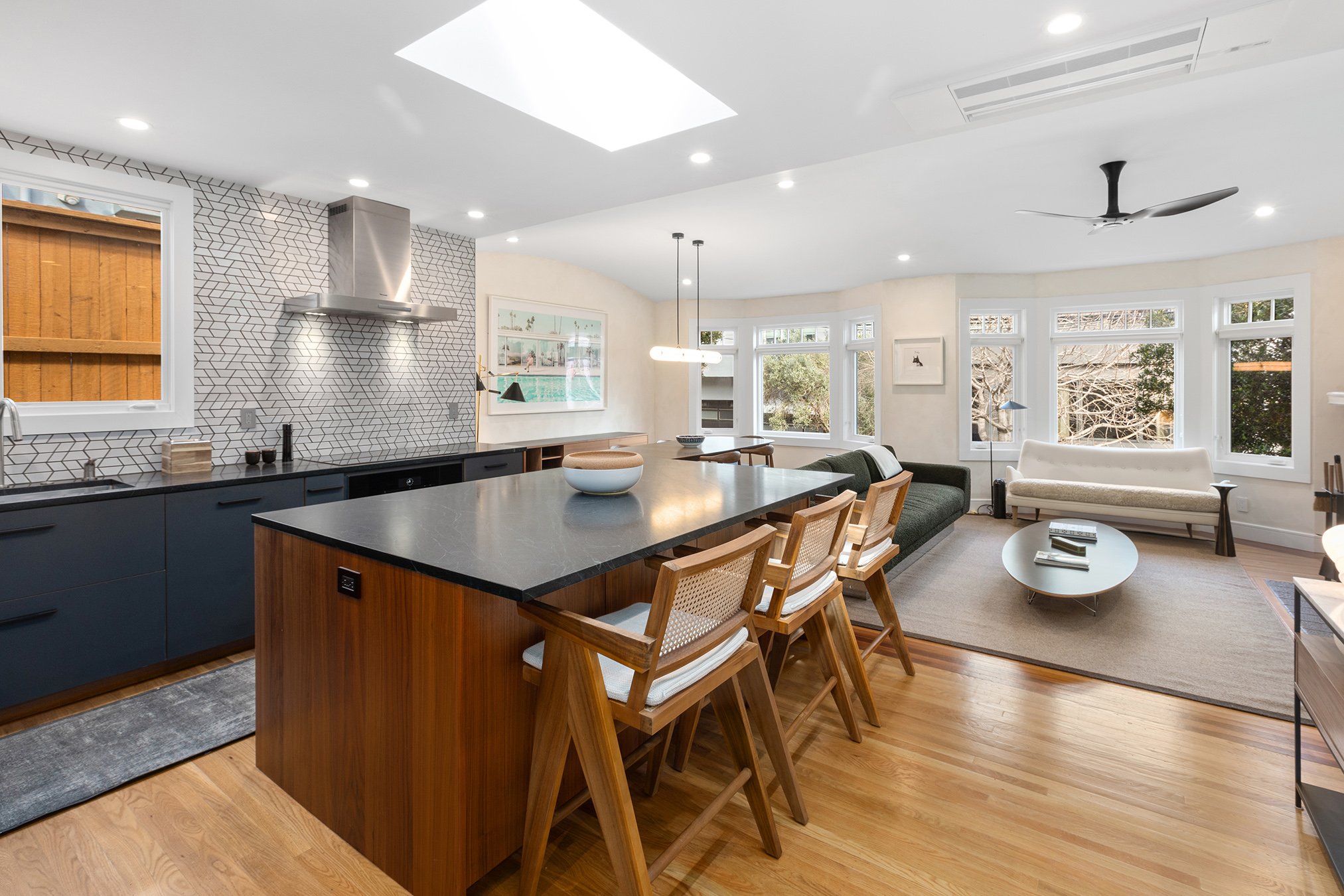 Open floor plan view, showing kitchen, dining, and living room with wood floors
