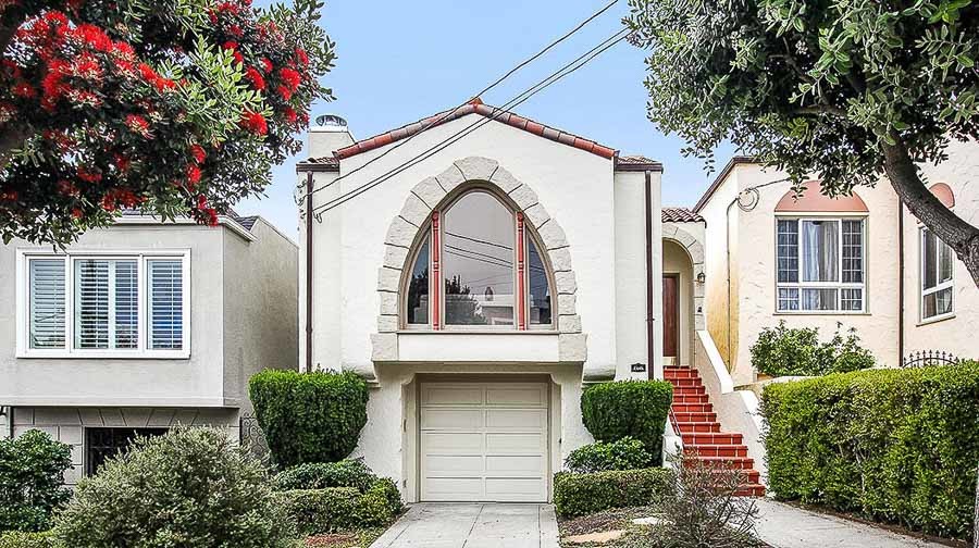 Front exterior view of 2445 Funston Avenue, showing a home with a large arched window and tan facade