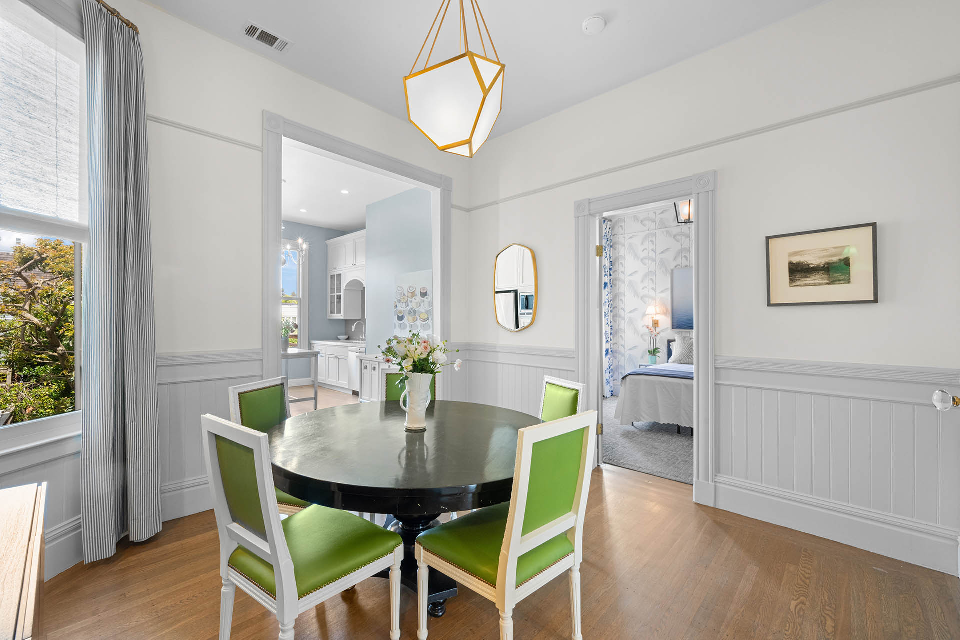 Dining room has hardwood floors throughout. You can see the guest room door.