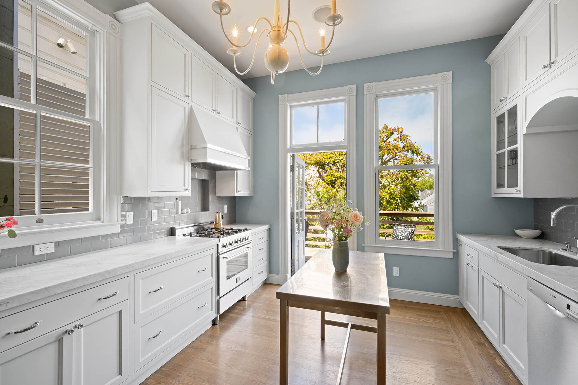There are white cabinets and natural stone countertops.