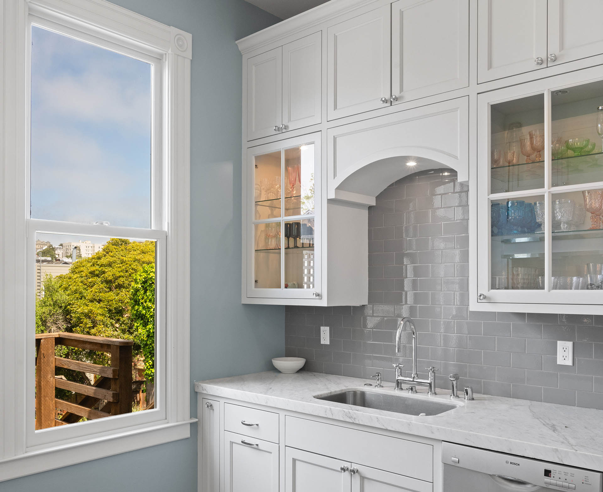 The cabinets next to the sink have beautiful glass doors.