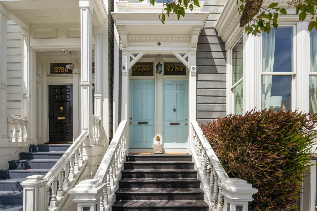 Photo looking up at the front stairs at the light blue doors.