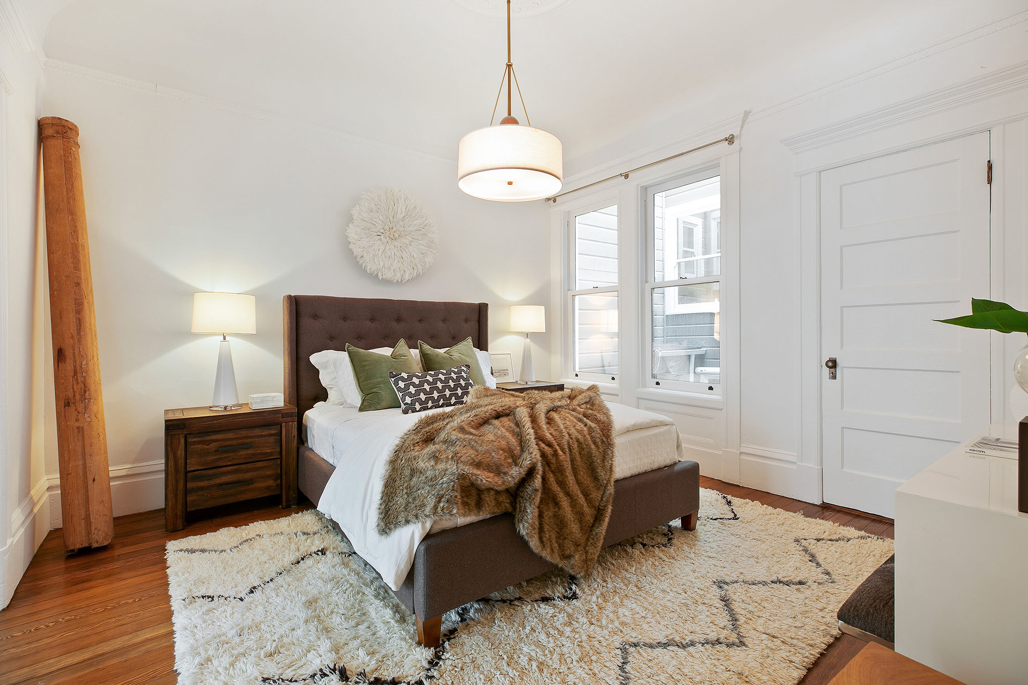 28 View of a bedroom with wood floors and two large windows