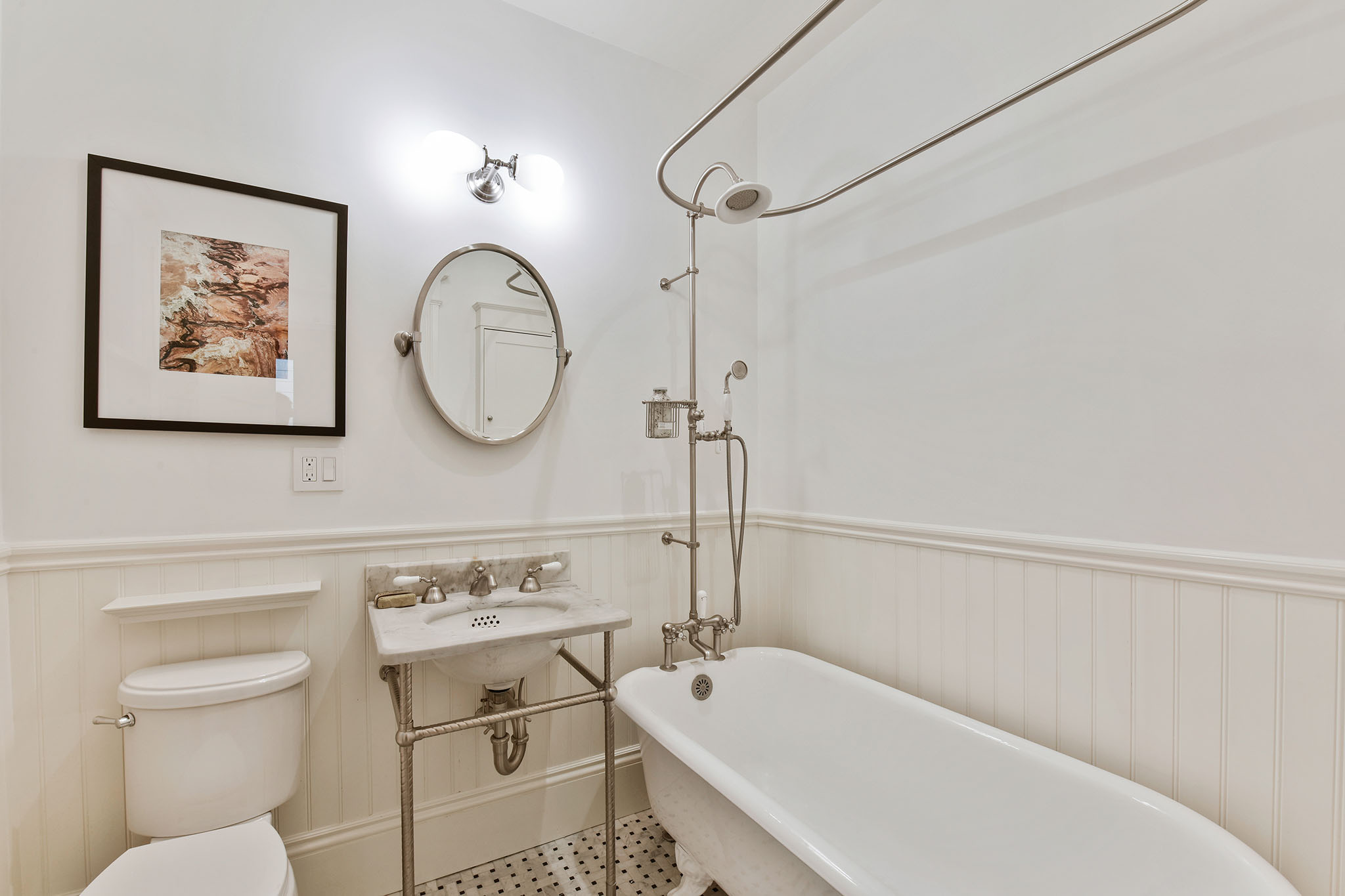 Bathroom with free-standing bath tub and white wainscoting