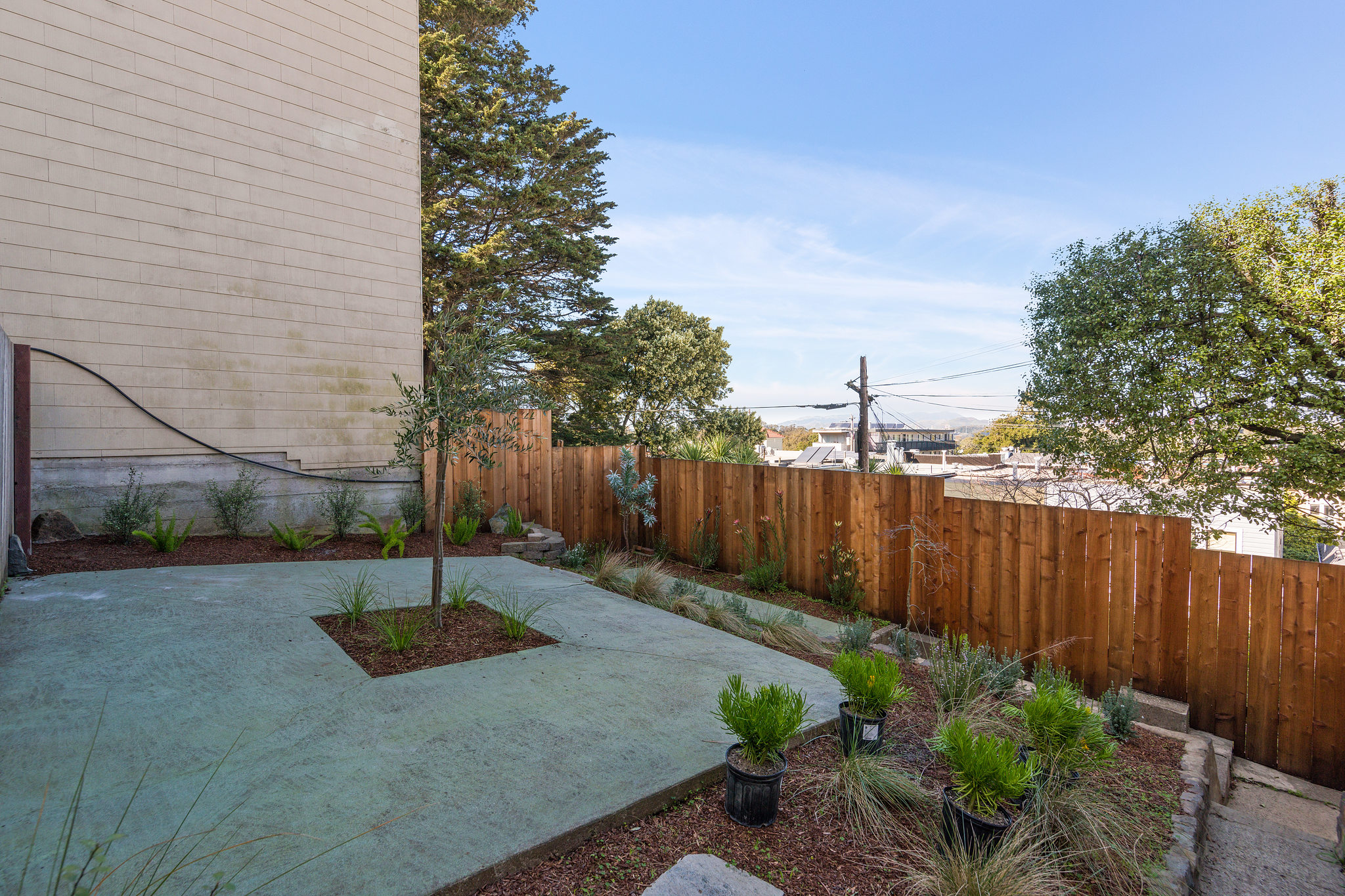 Exterior view of the outdoor space, featuring a wood fence