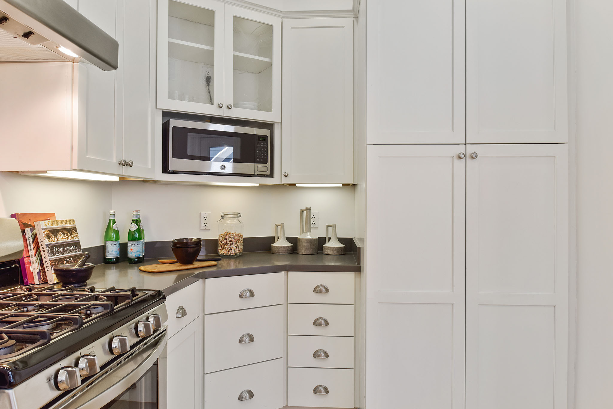 Kitchen, featuring a stainless stove and white cabinets