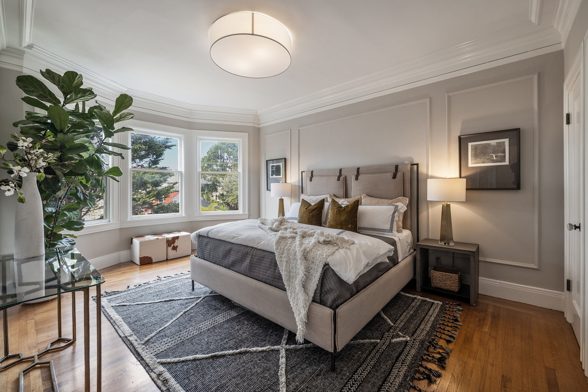 View of the primary bedroom, featuring wood floors and crown moulding