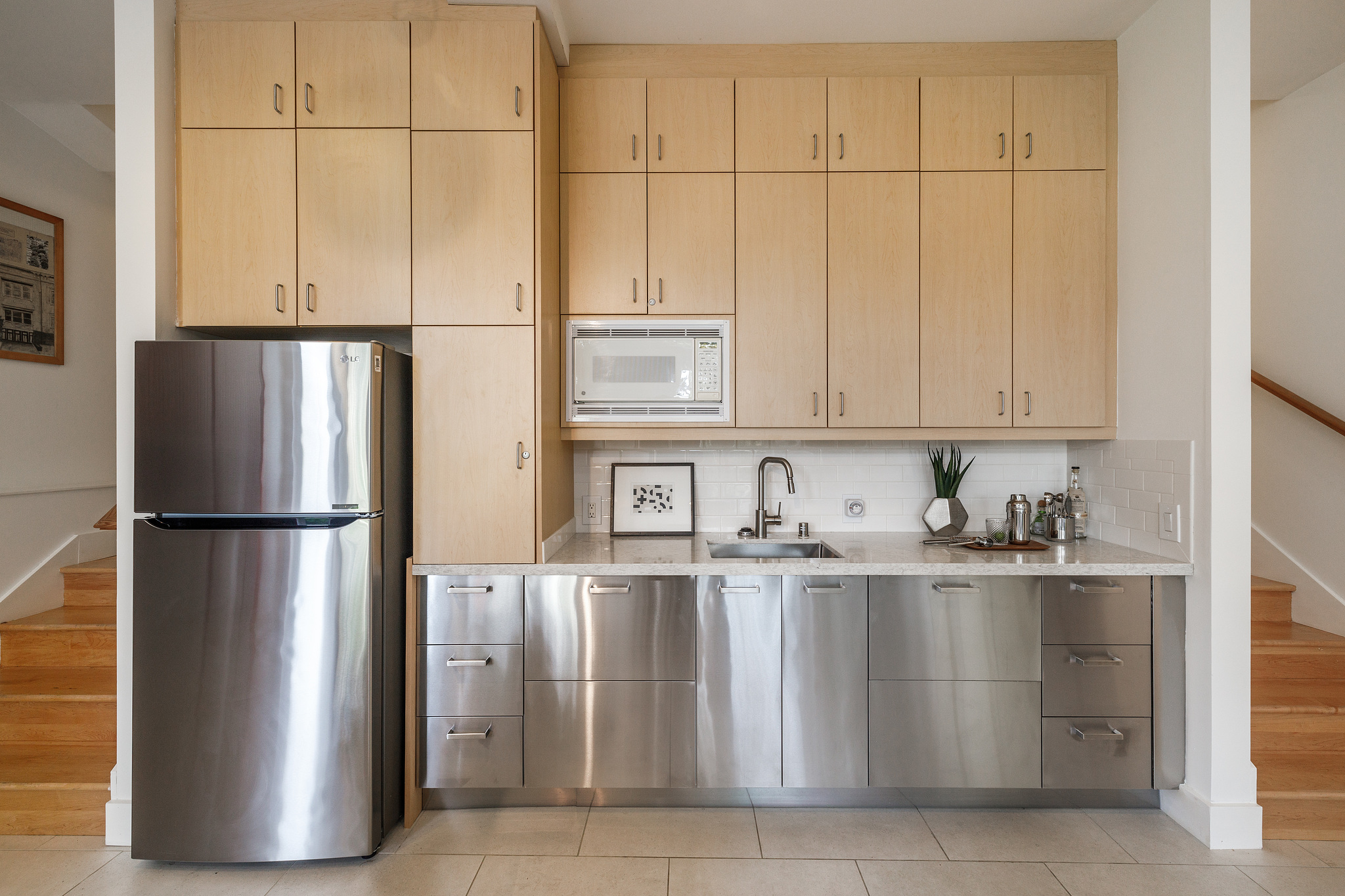 Close-up of lower level partial kitchen with sink and fridge
