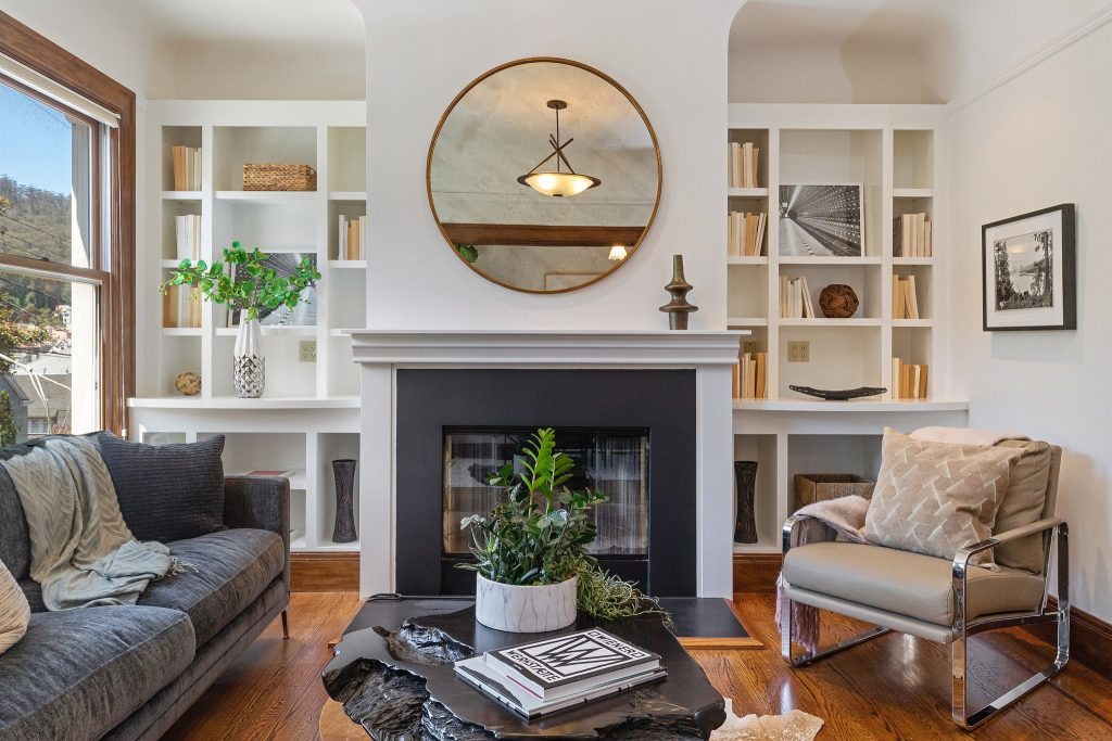 A dark wood fireplace, black coffee table and large mirror decorate the living room of 38 Parnassus f