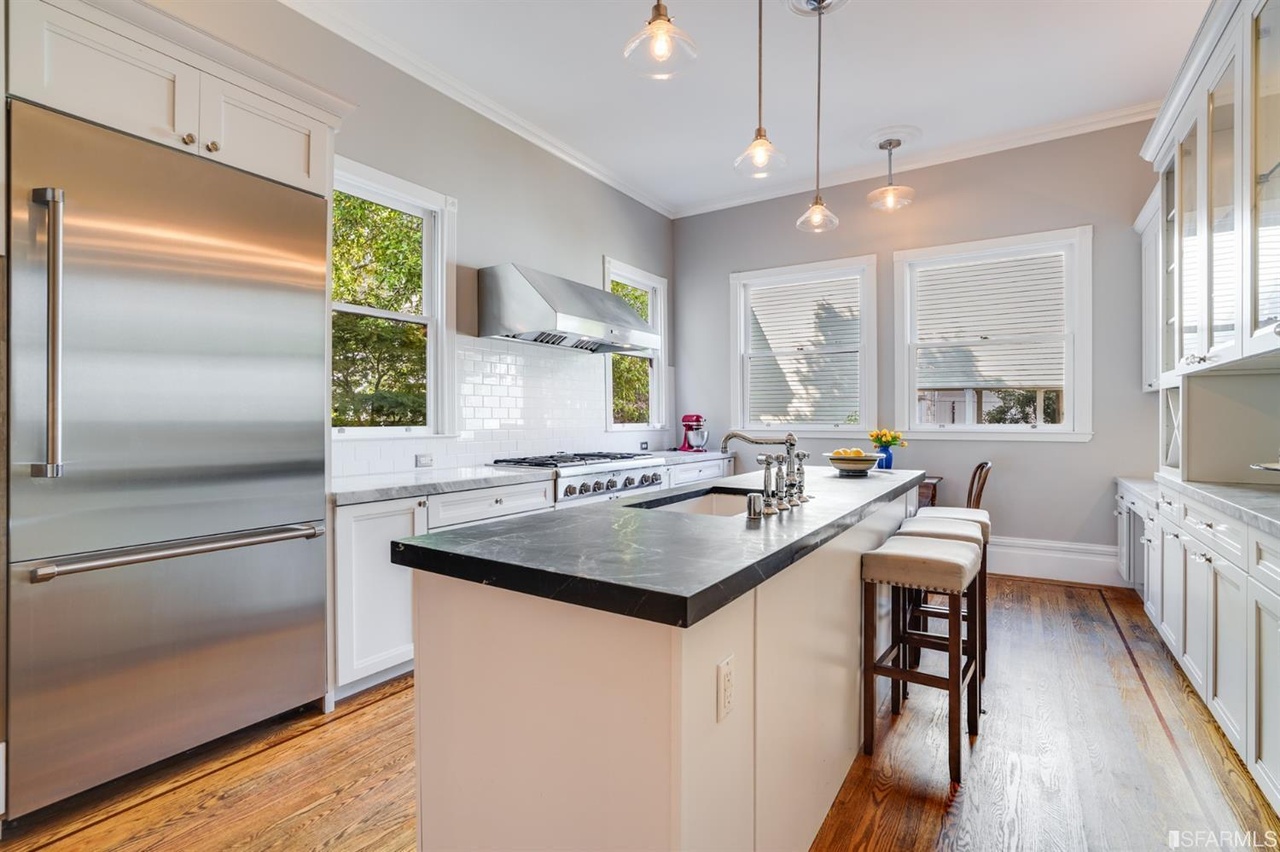 421594575141 View of the kitchen, featuring island cabinets with chairs