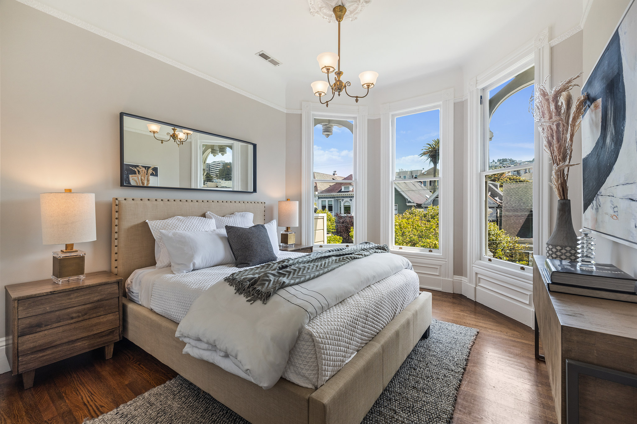 View of a bedroom with bay windows and wood floors