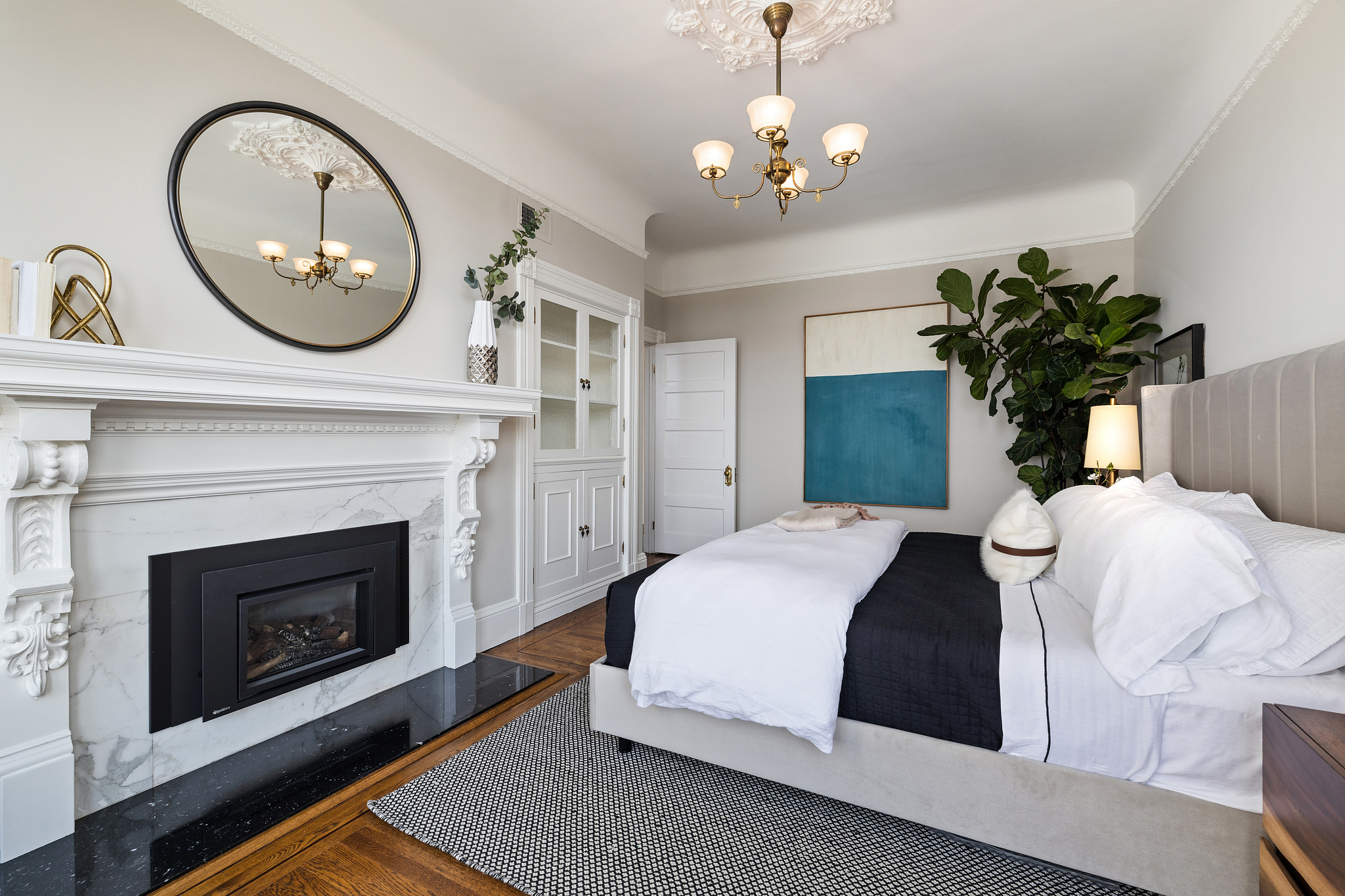 View of the primary bedroom showing built-in cabinets and fireplace
