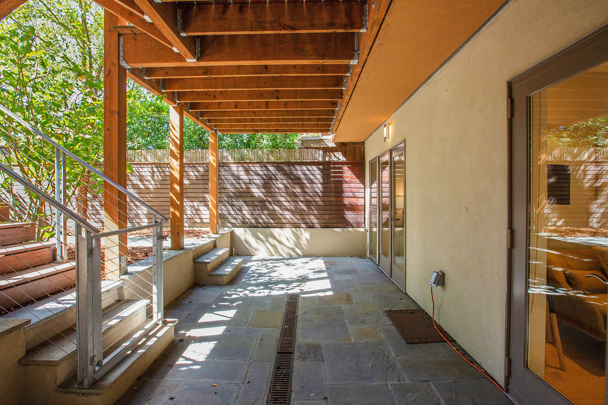 Photo of area under deck that lower bedroom/sitting room open up to. There is stone flooring.