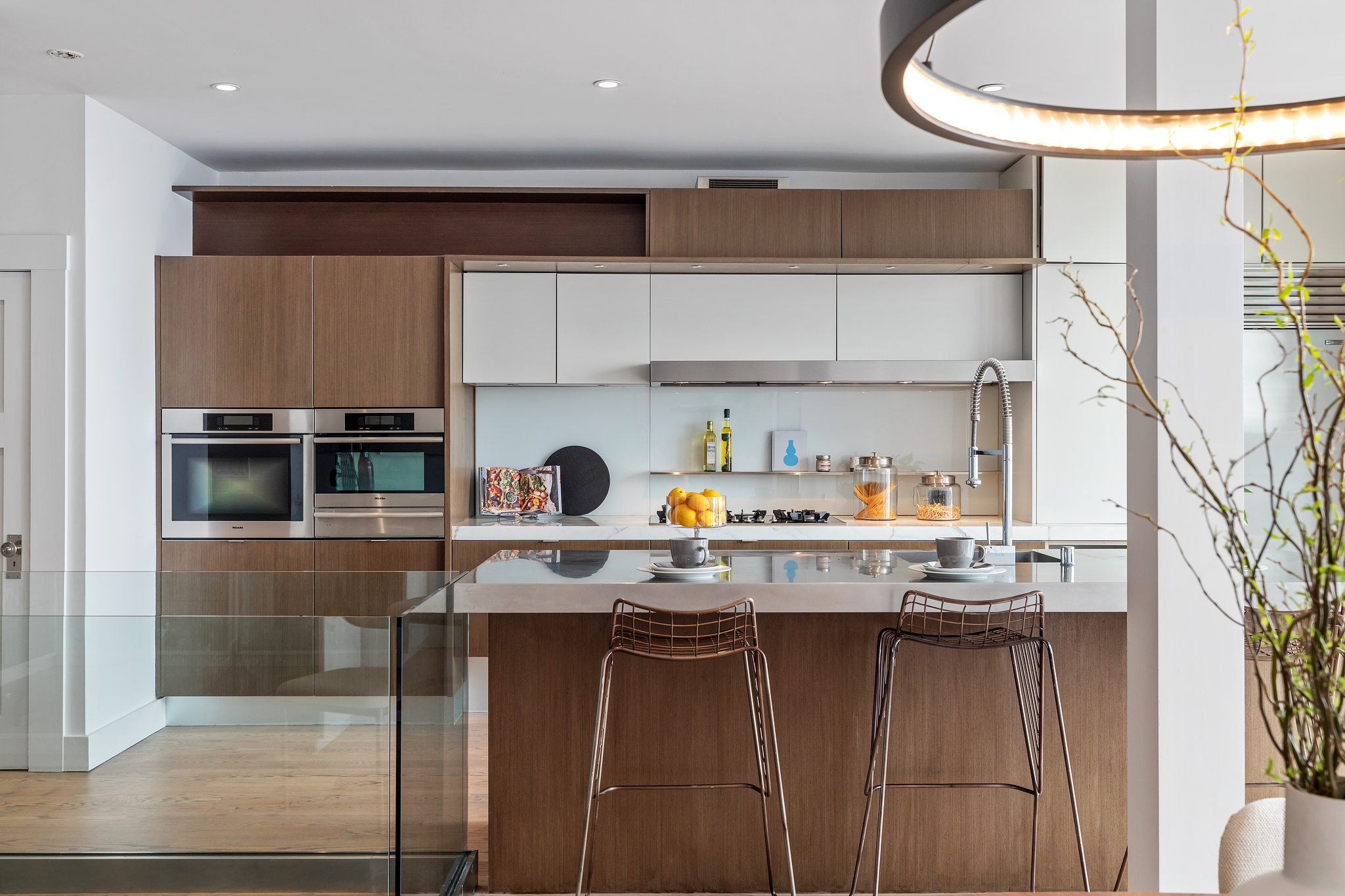 View of the kitchen, showing wood cabinets and modern island seating