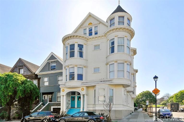 Front exterior view of 595 Waller Street, showing a turreted home with cream-colored facade