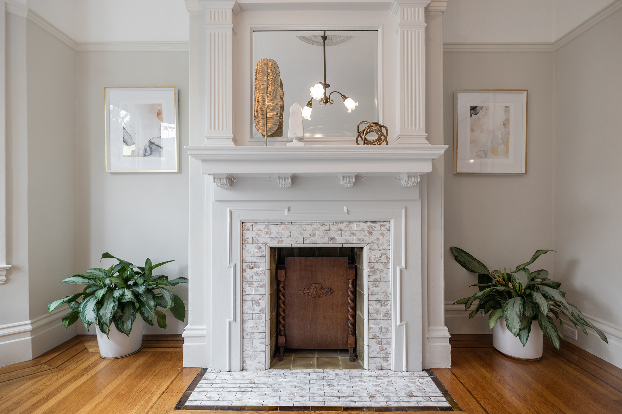Up-close view of a tiled fireplace with white wood