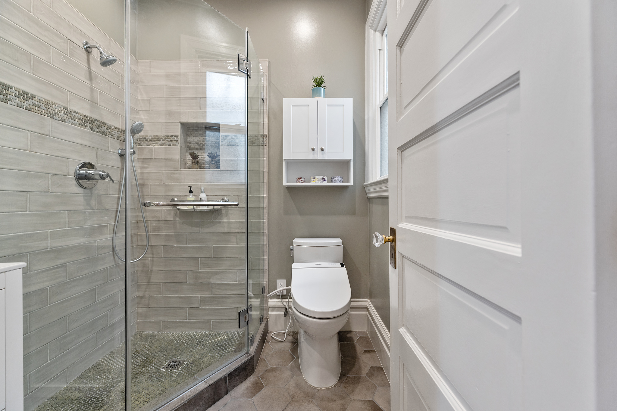 A glass shower and entry-way to a bathroom
