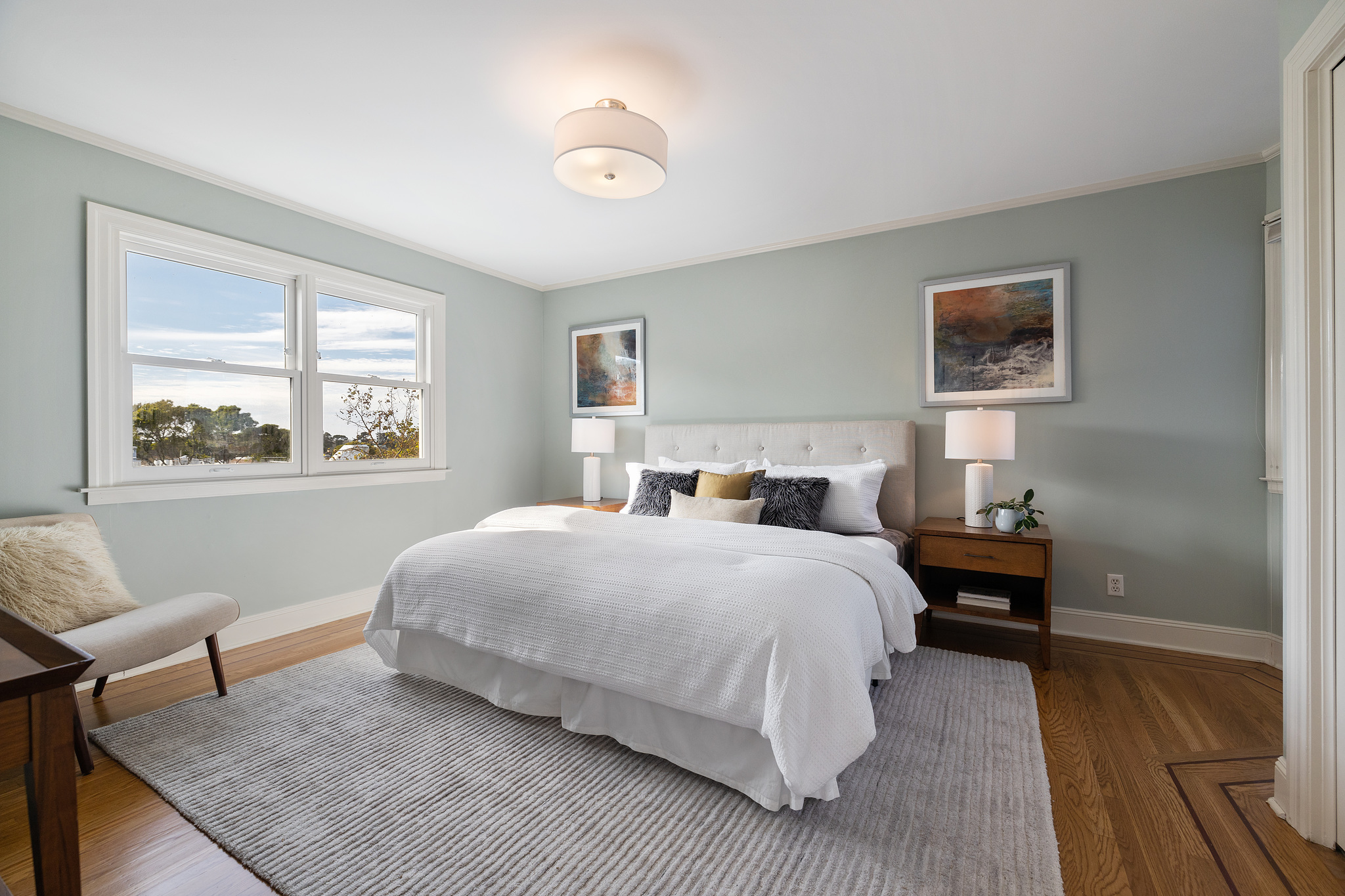 Large bedroom with two windows and wood floors