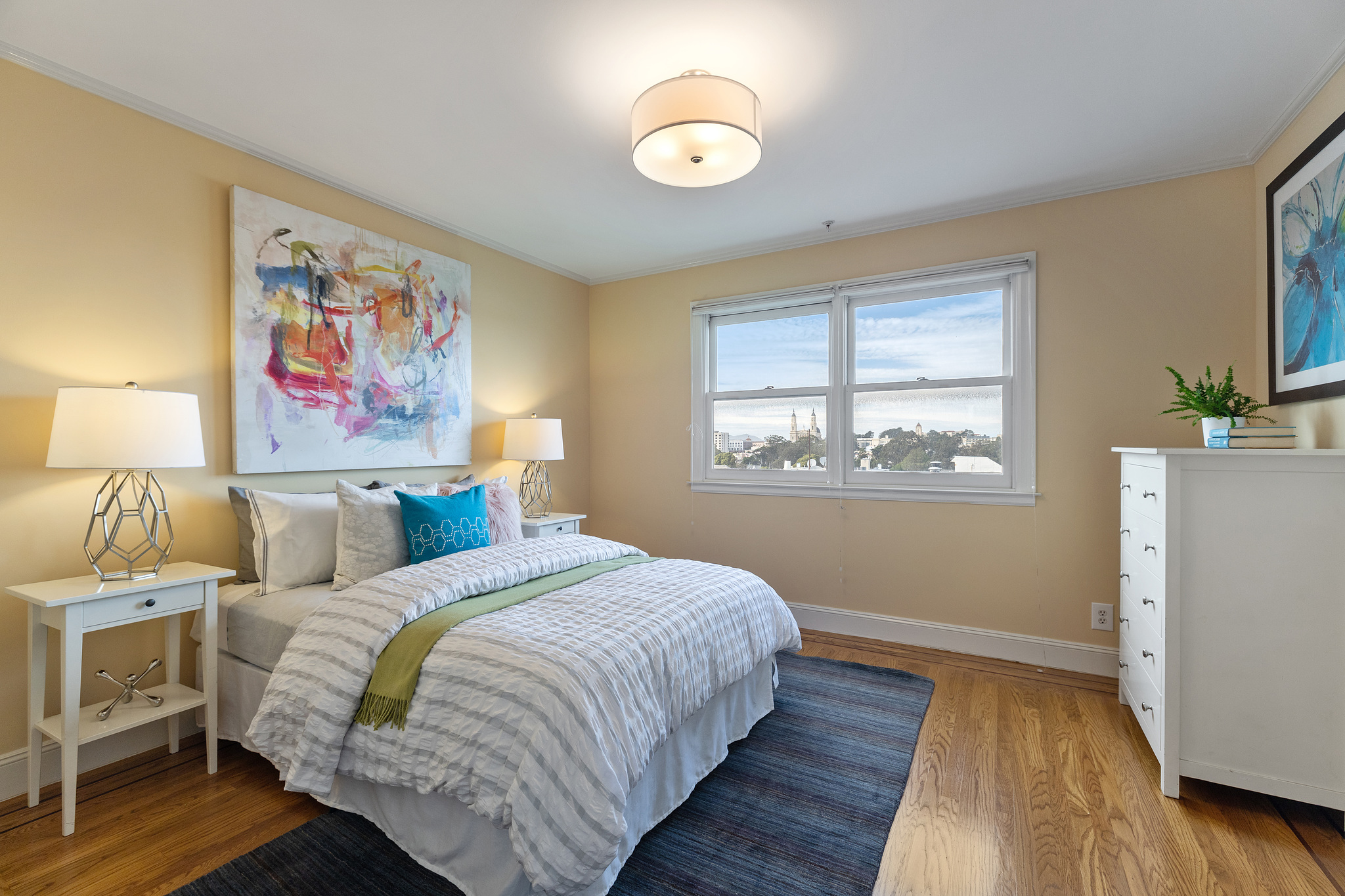 A yellow bedroom with two large windows