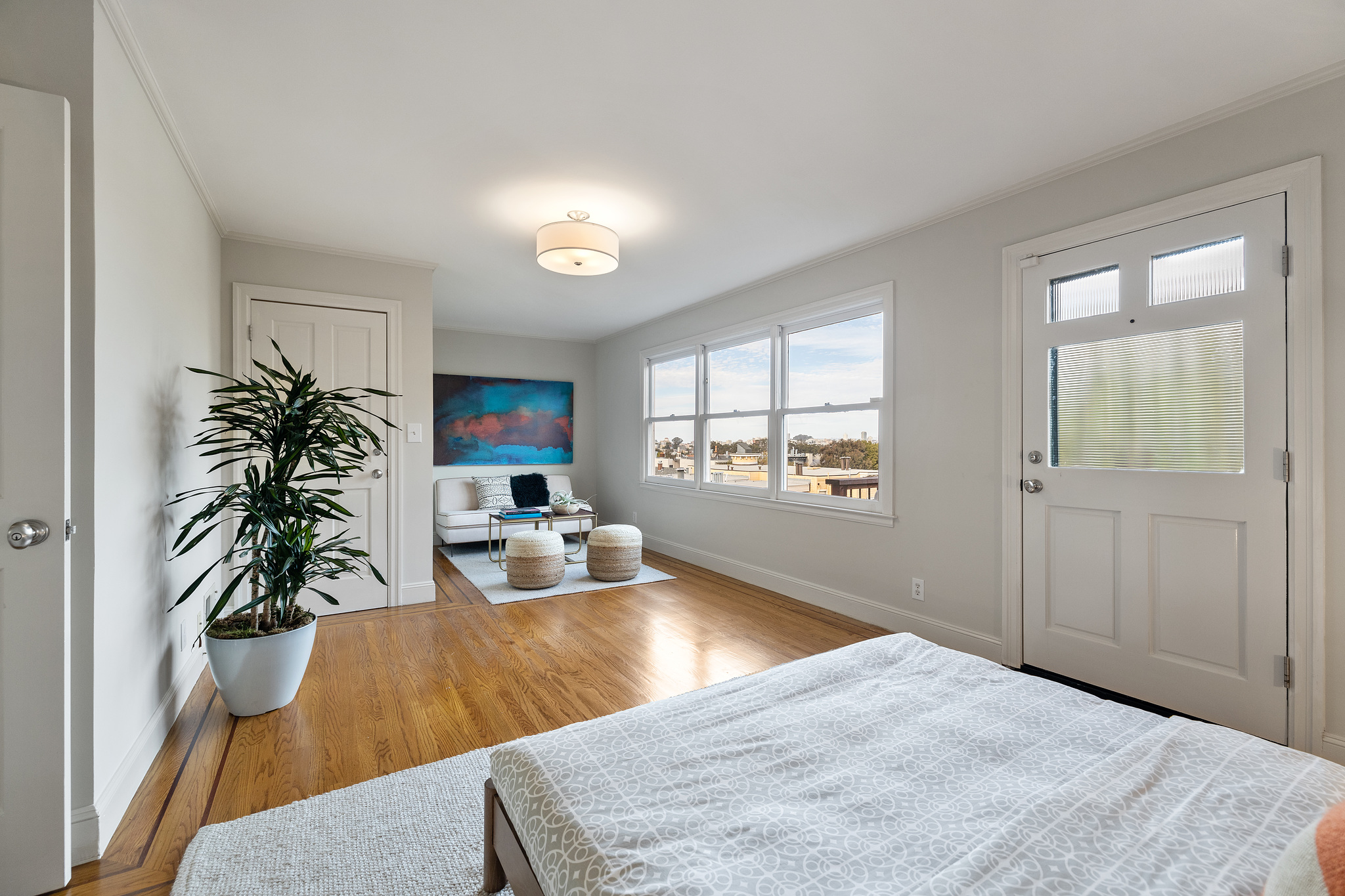 Long-view of a bedroom with seating area and deck access