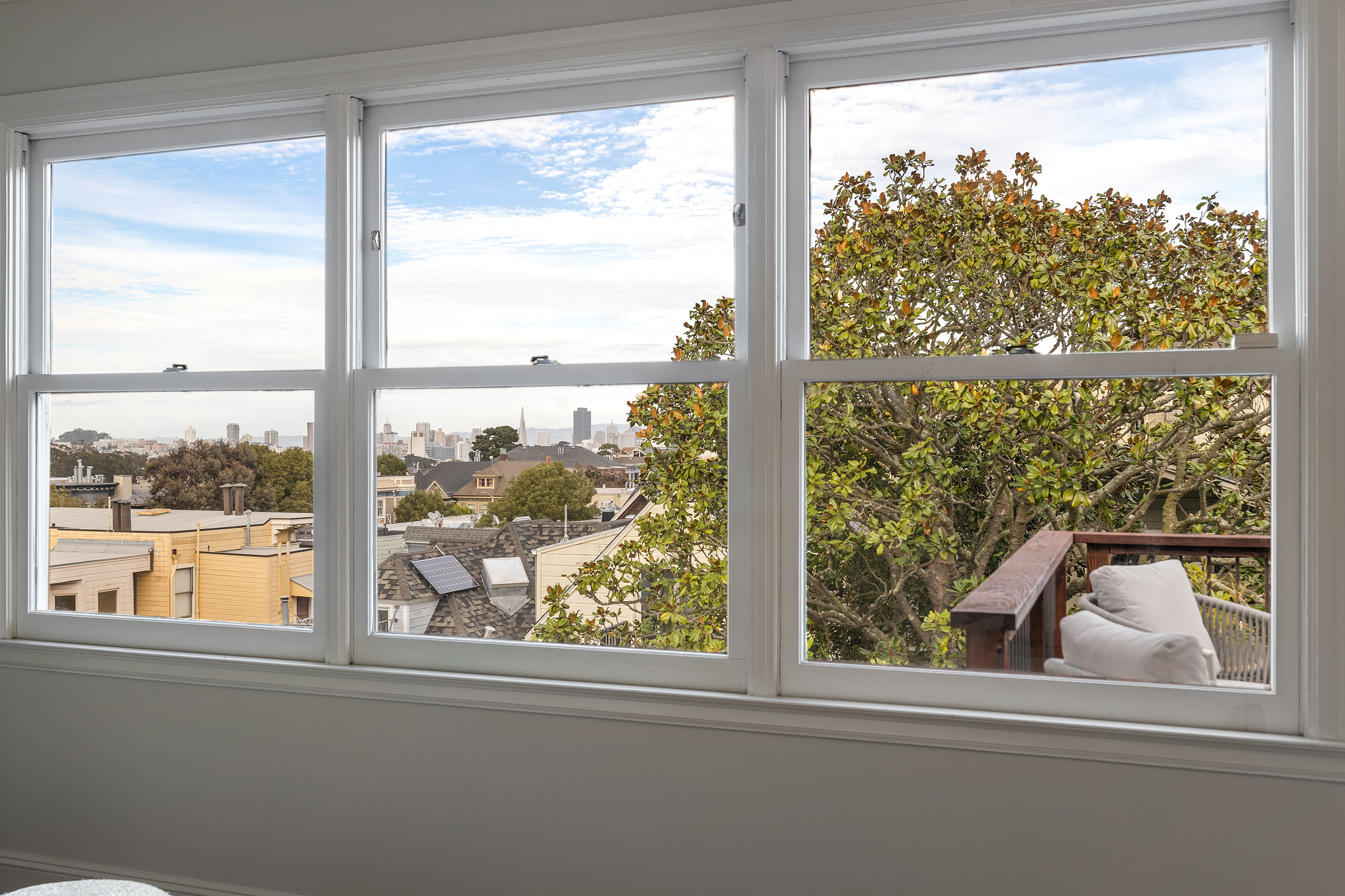 Three large windows provide sweeping views of San Francisco