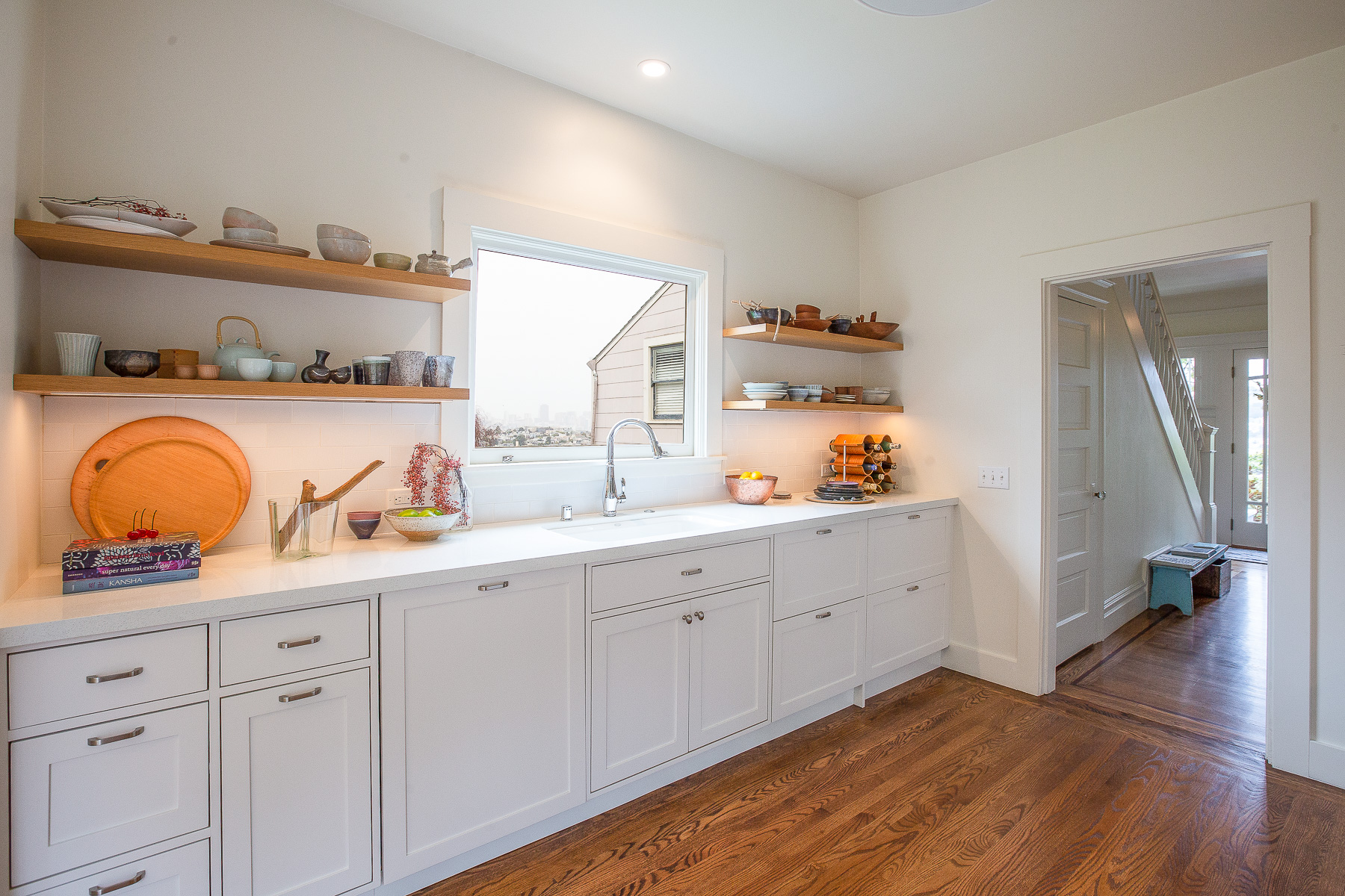 Close-up view of the white cabinets and open shelves in the kitchen