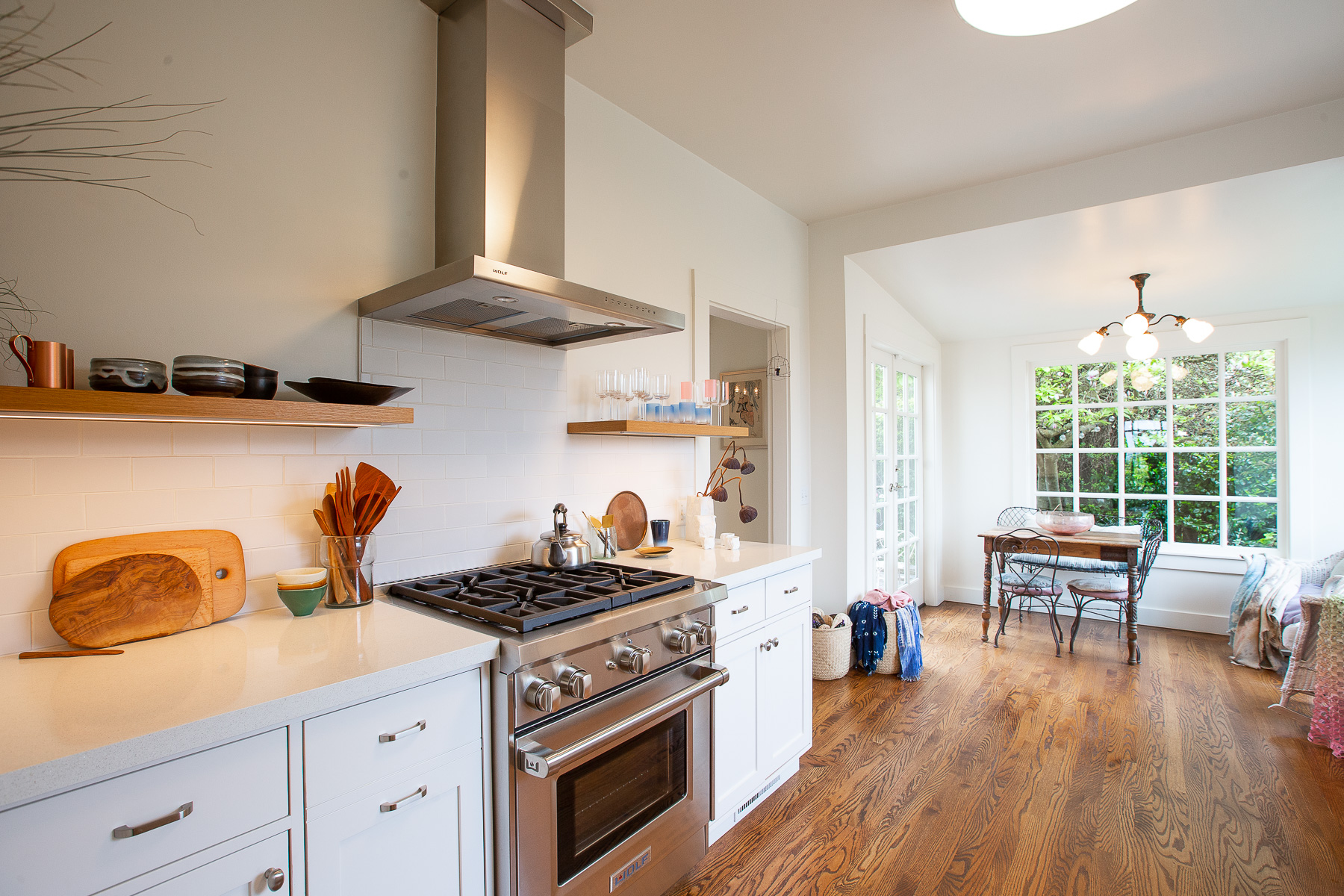View of the stainless stove and adjoining eat-in sunroom