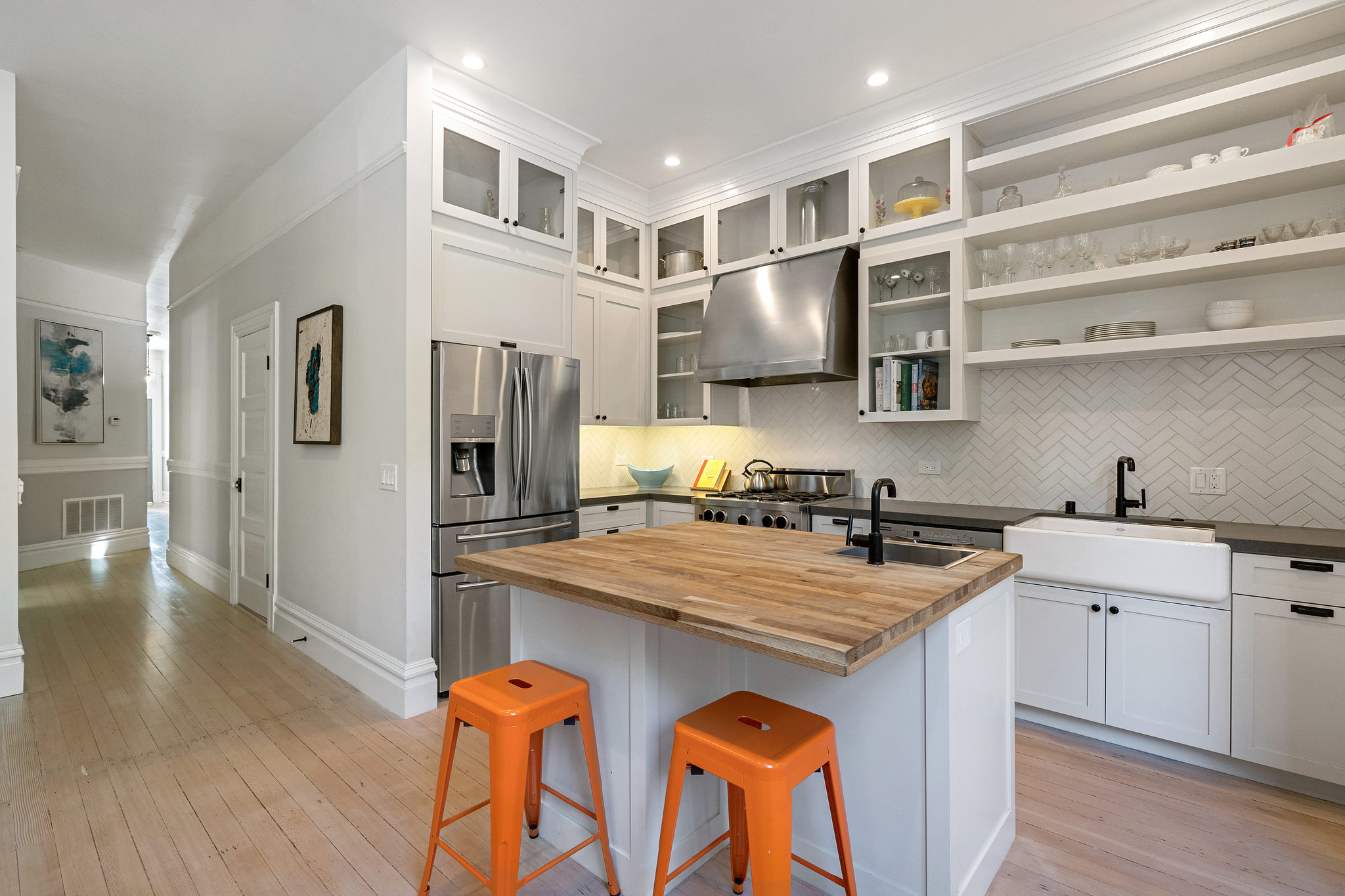 View of the kitchen, featuring white cabinets and wood floors