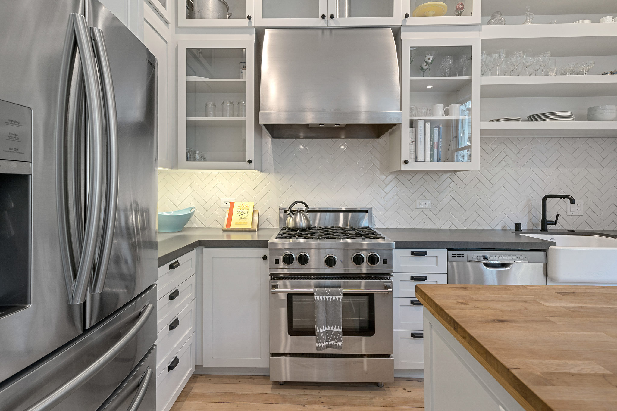Kitchen with stainless steel appliances and glass front cabinets