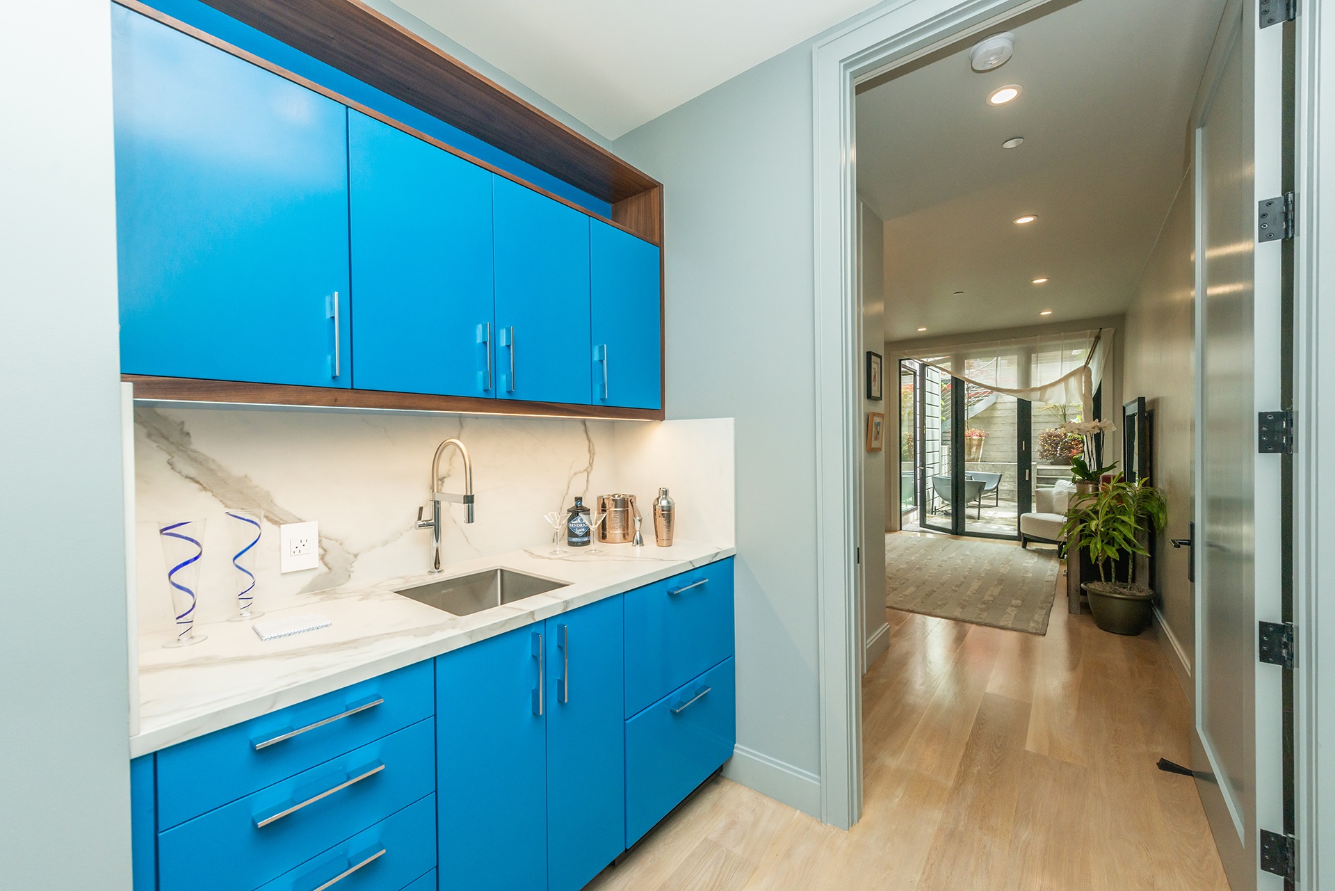 The built in wet bar on lower lever. Bright blue cabinetry with white counters and small stainless sink.