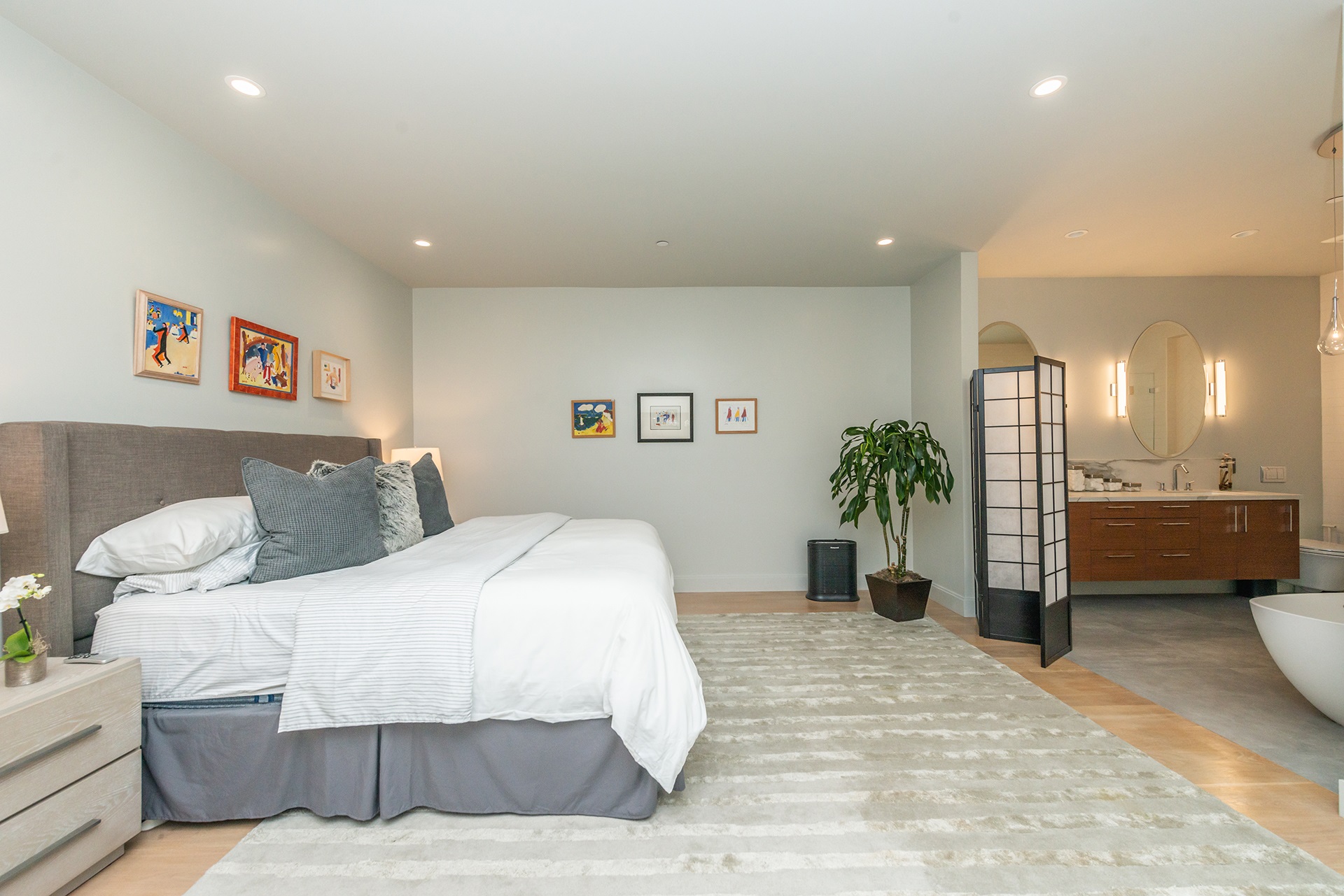 There is a large king bed to left and bathroom that is open to room is on the right.