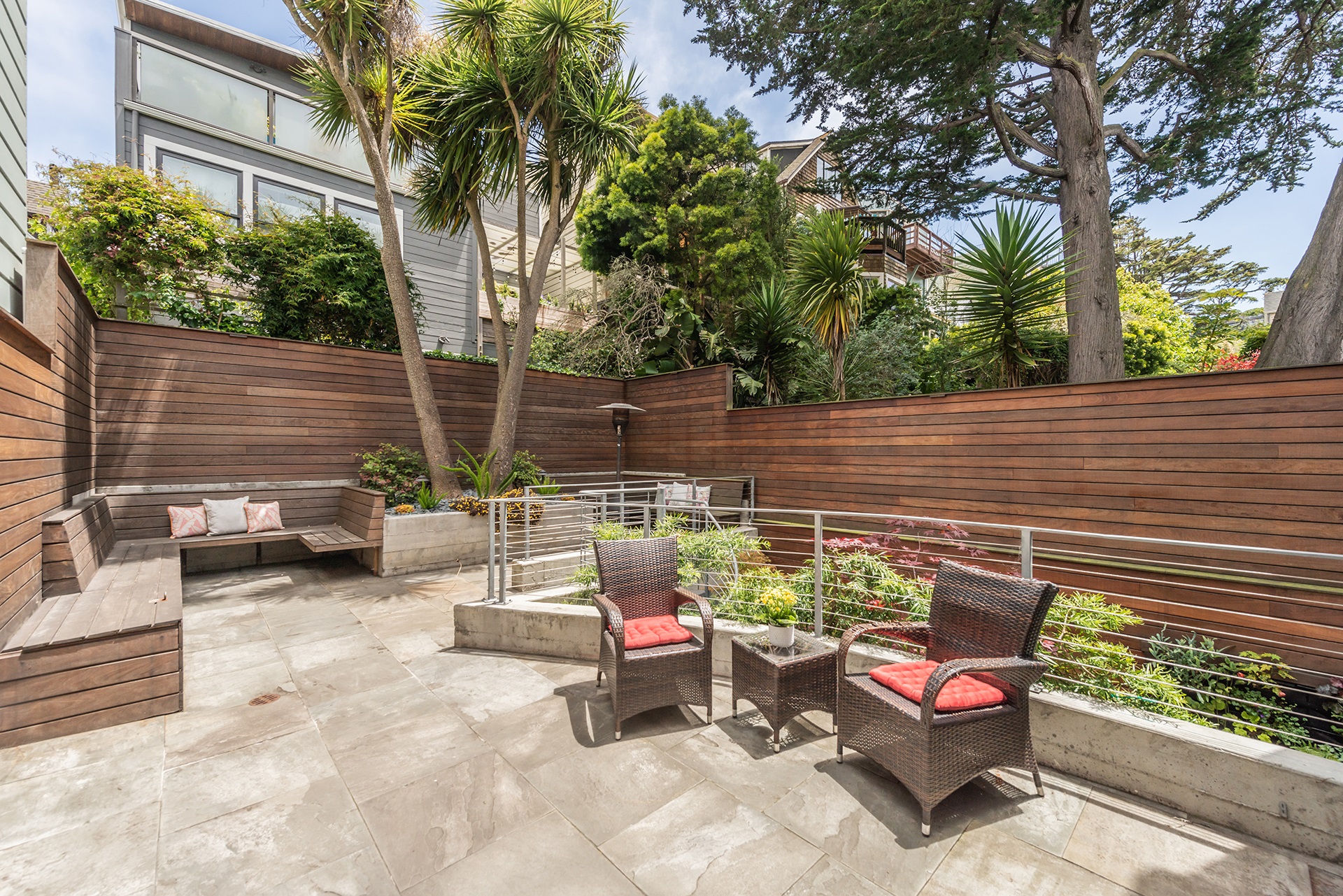 Yard in fenced in with wood fence. There are multiple seating areas and tile flooring.