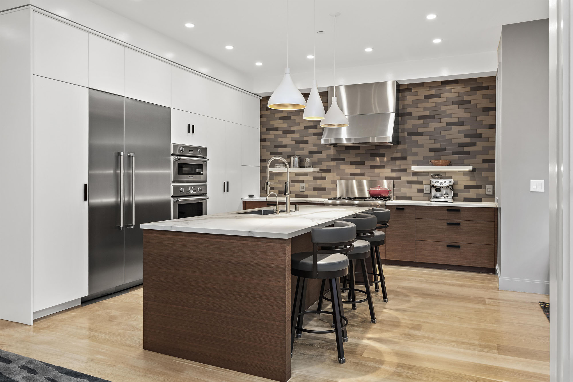 The left side wall in the kitchen in built in cabinets, stoves, and fridge. All stainless steel appliances.
