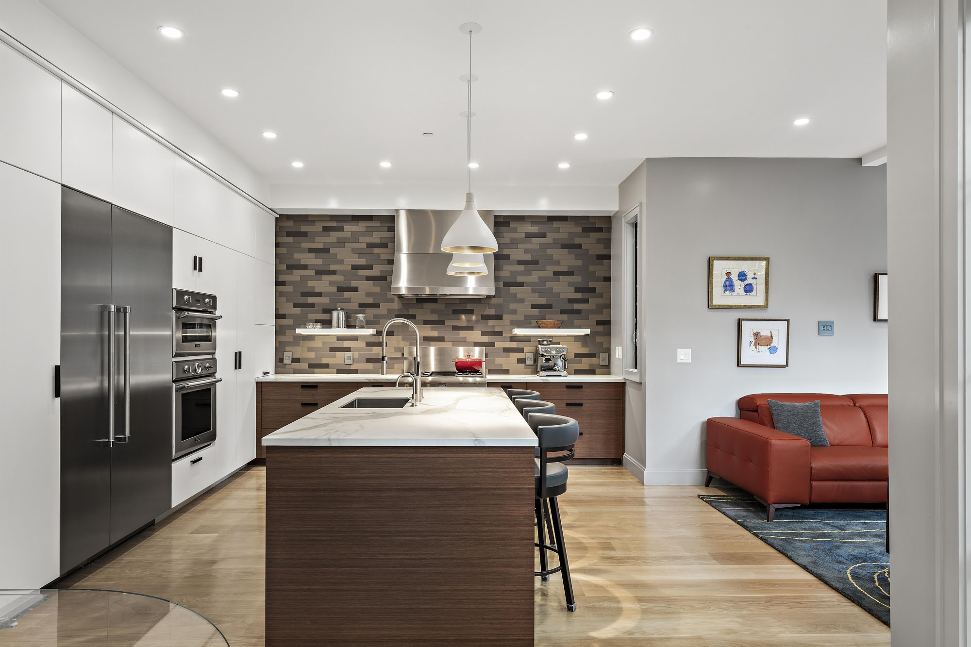 Looking into the kitchen of Unit 1. There is a large island with sink and stools.