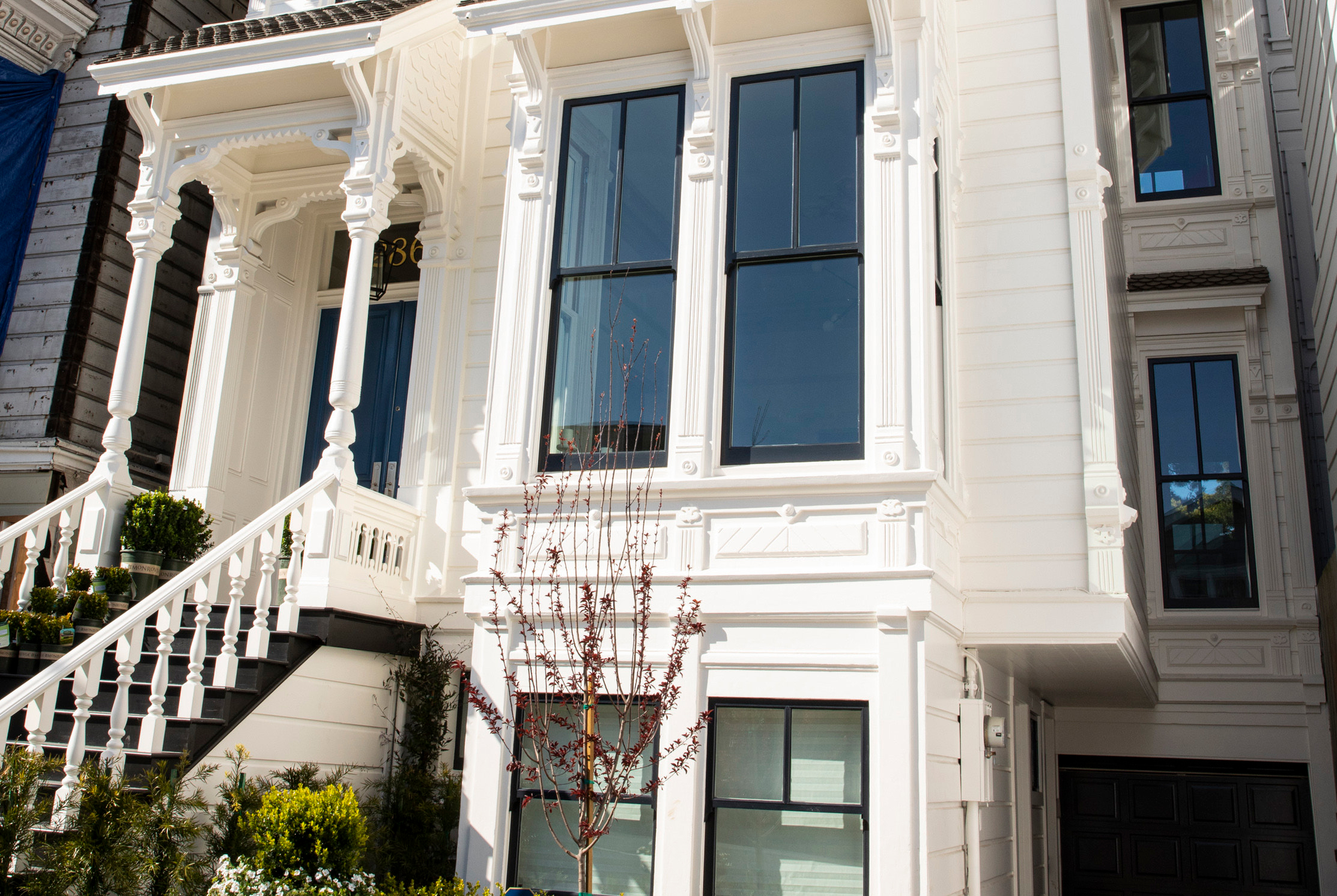 Exterior side view of 2862 Bush, showing white railing and large front windows